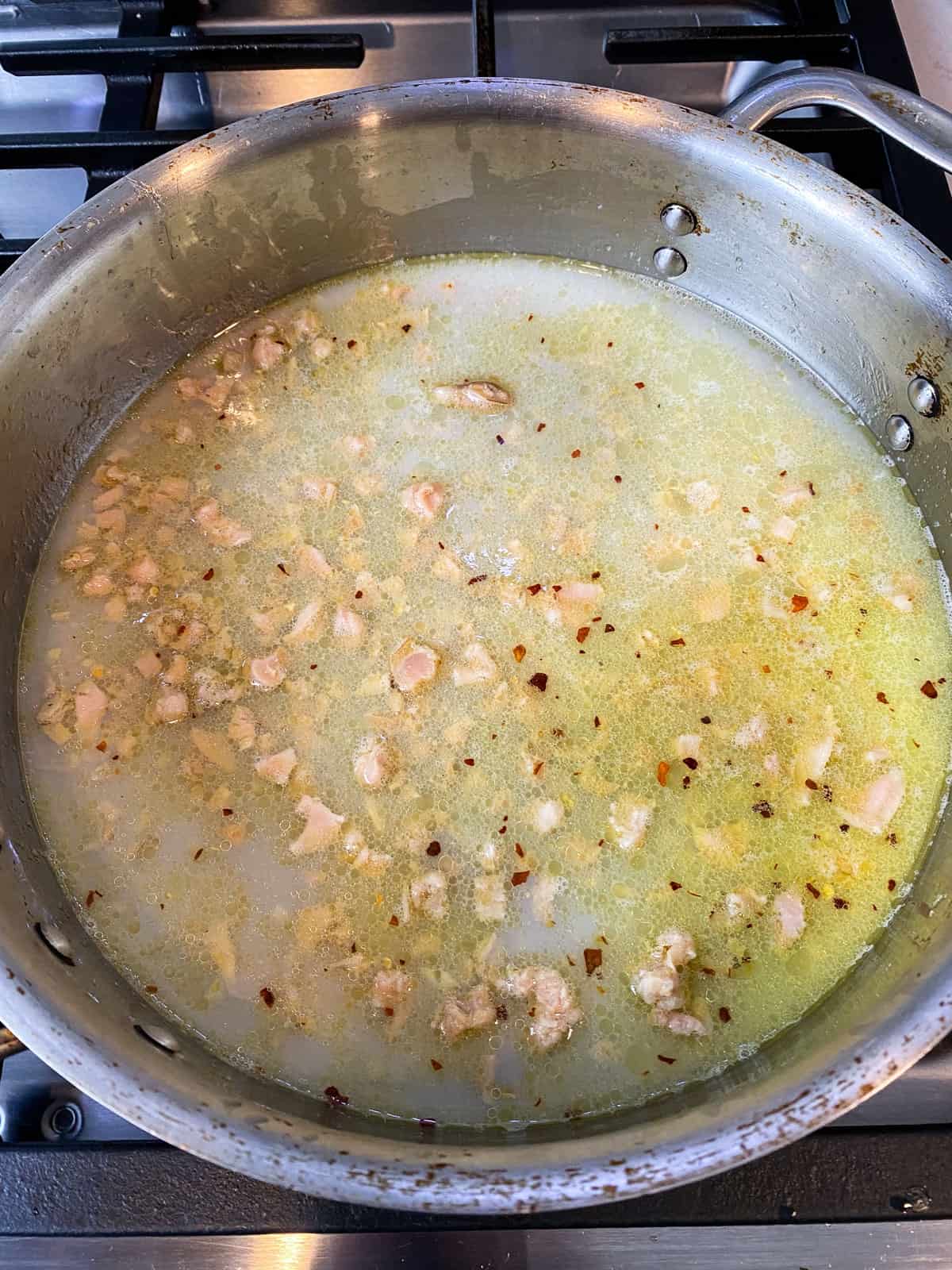 Add the canned clams with all their juices and the wien wine and simmer for a few minutes to cook off the wine.