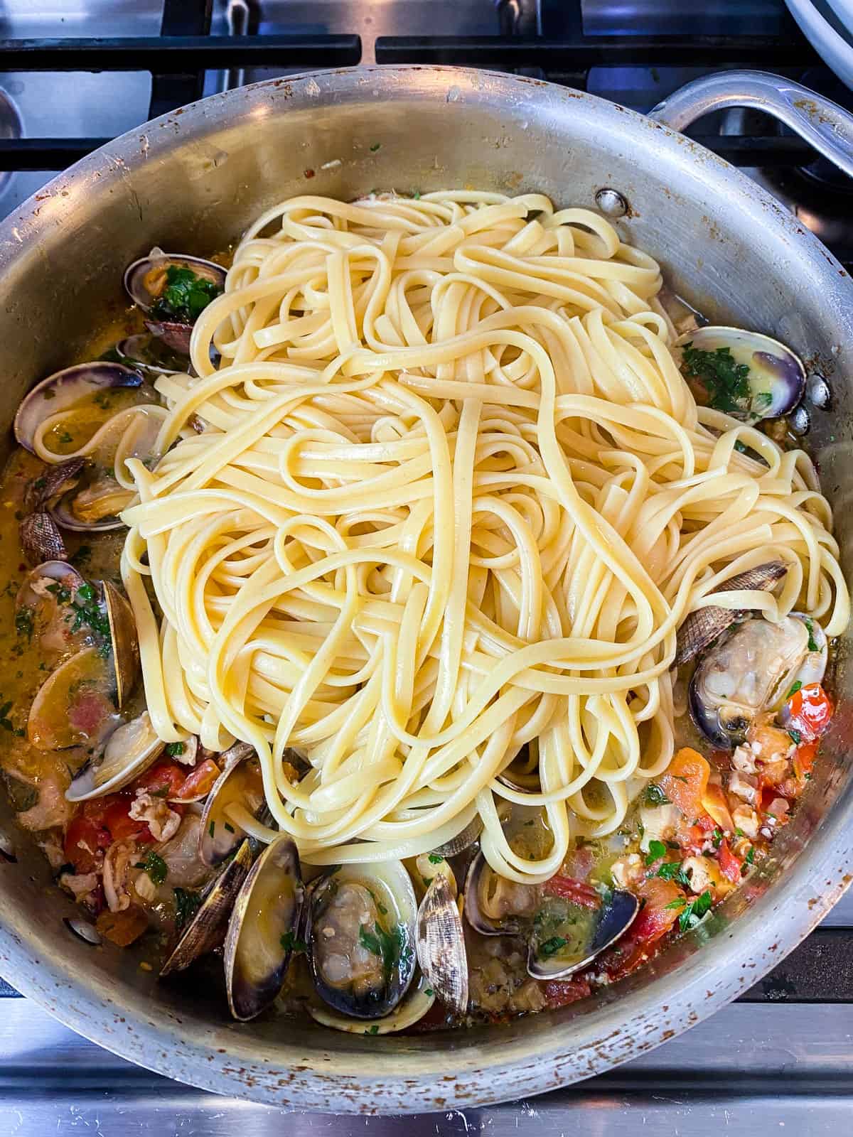 Add the cooked pasta to the clam pasta.