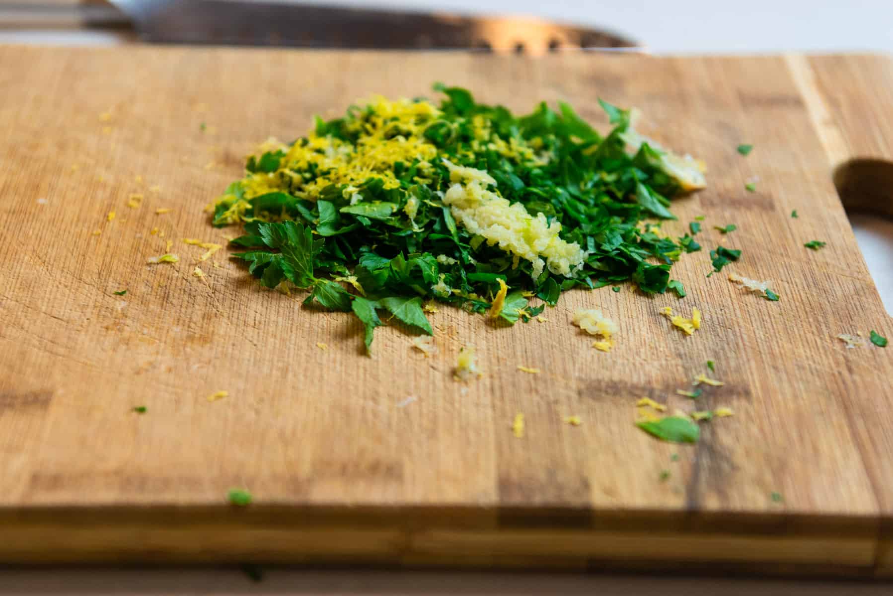 Add grated garlic to the parsley and lemon zest mixture.