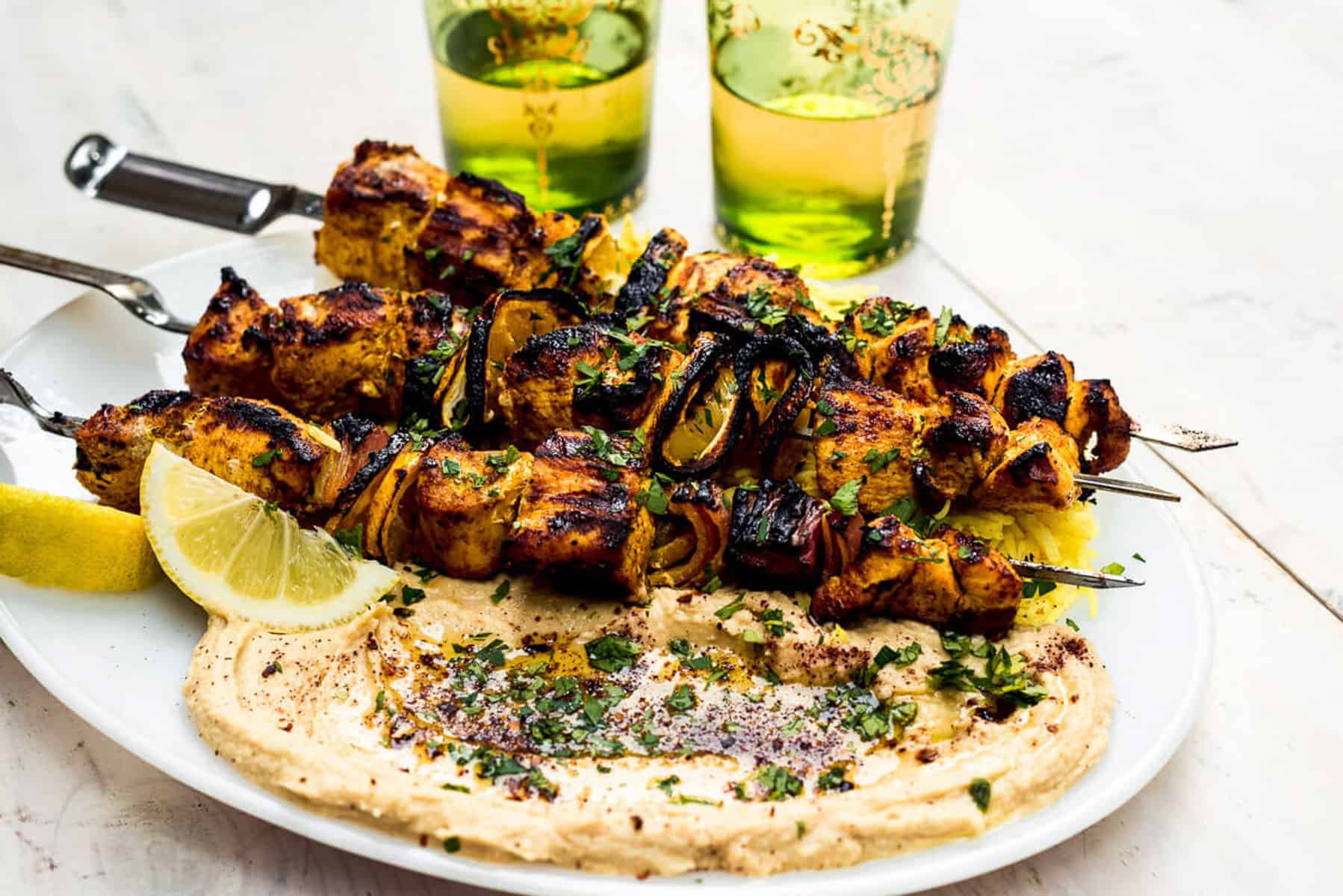 Chicken shawarma kebabs served with lemon, hummus and saffron rice.