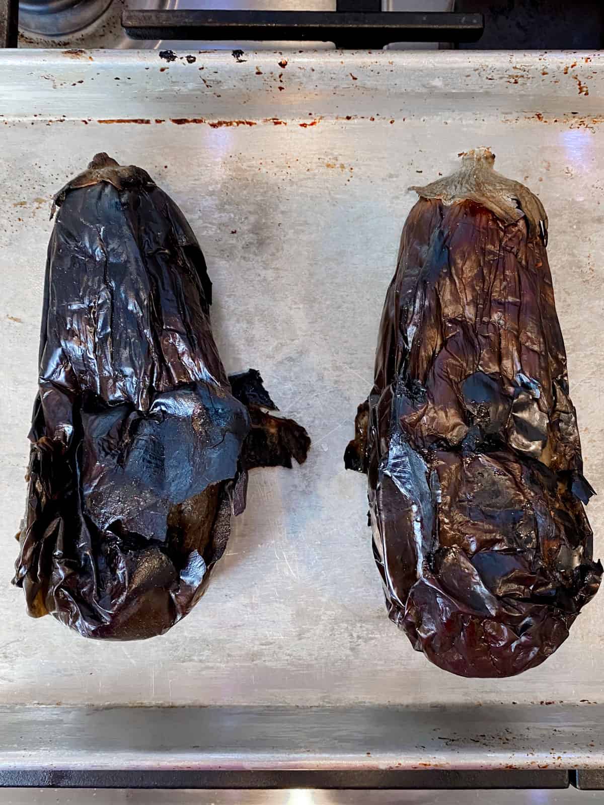 Once the eggplant is charred, the peel should be charred and begin to peel away from the flesh.