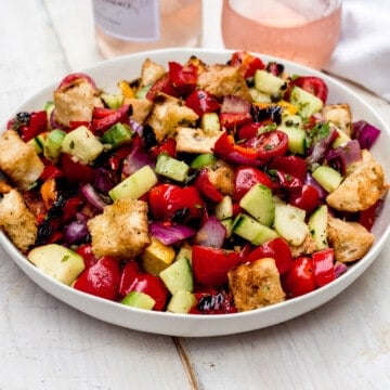 Grilled panzanella salad combines grilled peppers and onions with sweet cherry tomatoes and grilled bread and tossed with a balsamic vinaigrette.