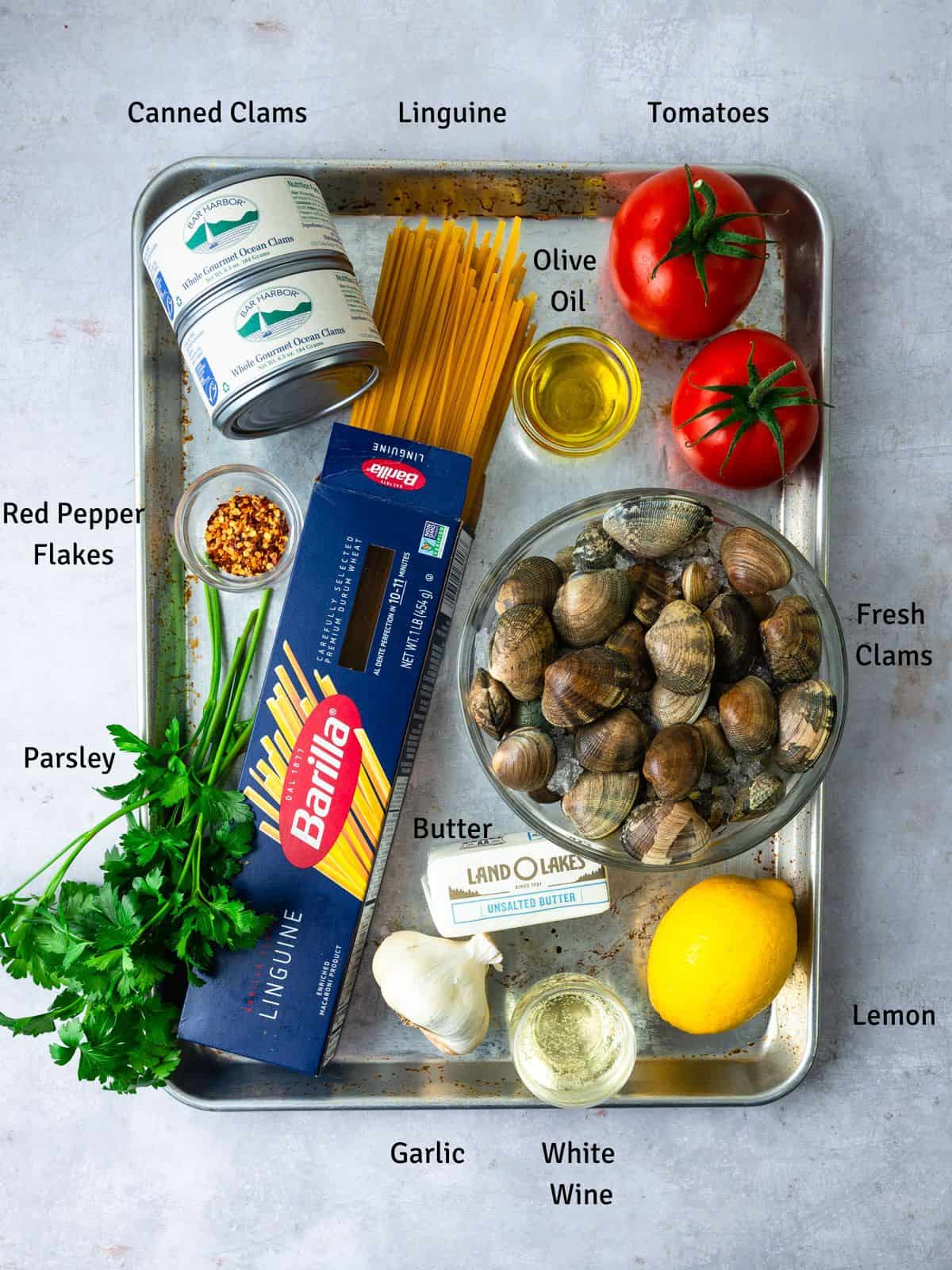 Ingredients for linguine with clams, including tomatoes, canned clams and white wine.