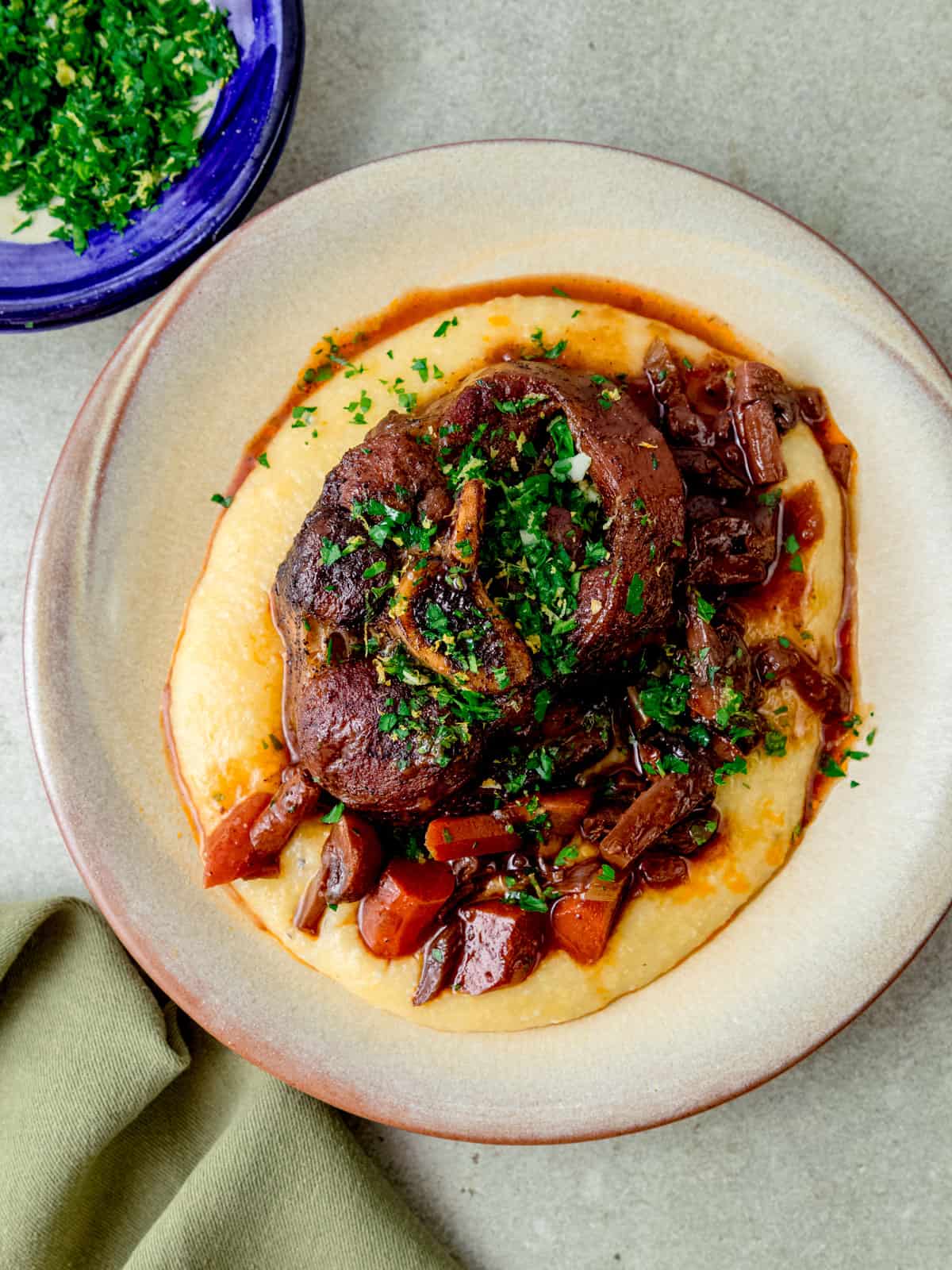 Osso buco with parsley gremolata that is served over creamy polenta.
