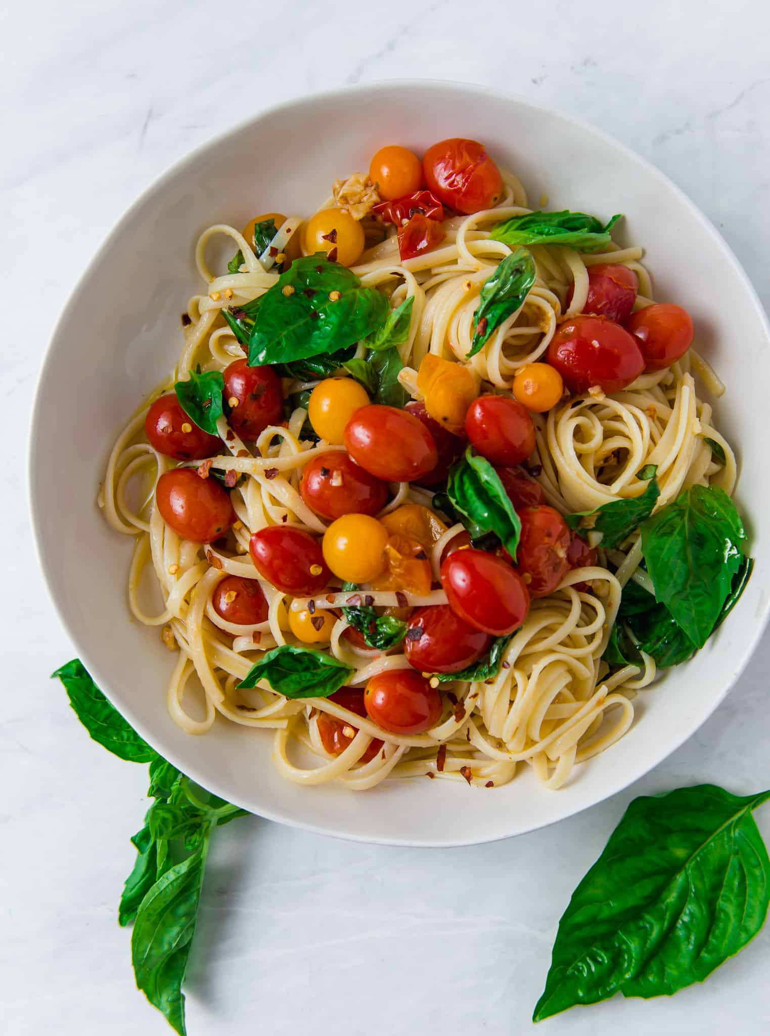 Pasta with cherry tomatoes, garlic, basil and red pepper flakes.