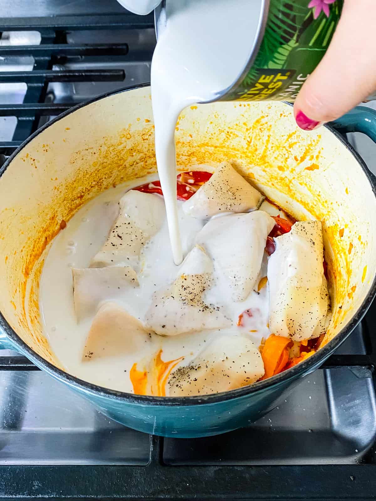 Pour a can of coconut milk into the Brazilian fish stew.