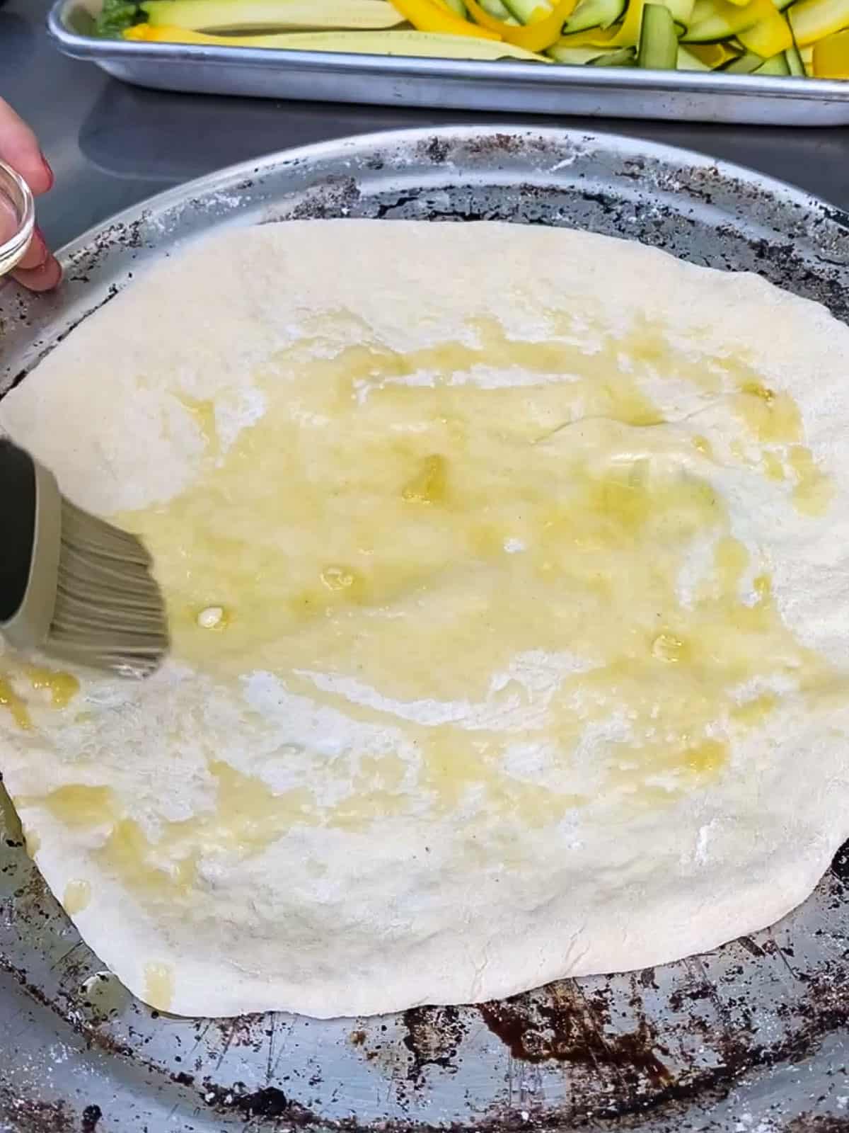 Brush garlic onto the stretched out pizza dough.