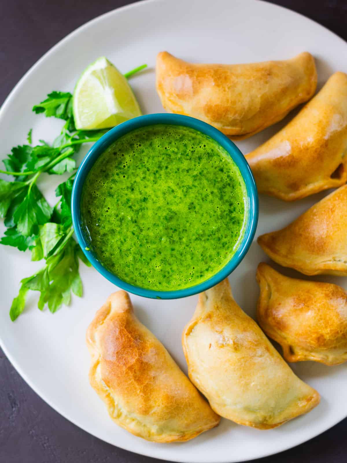 Baked brisket empanadas with chimichurri and fresh lime.