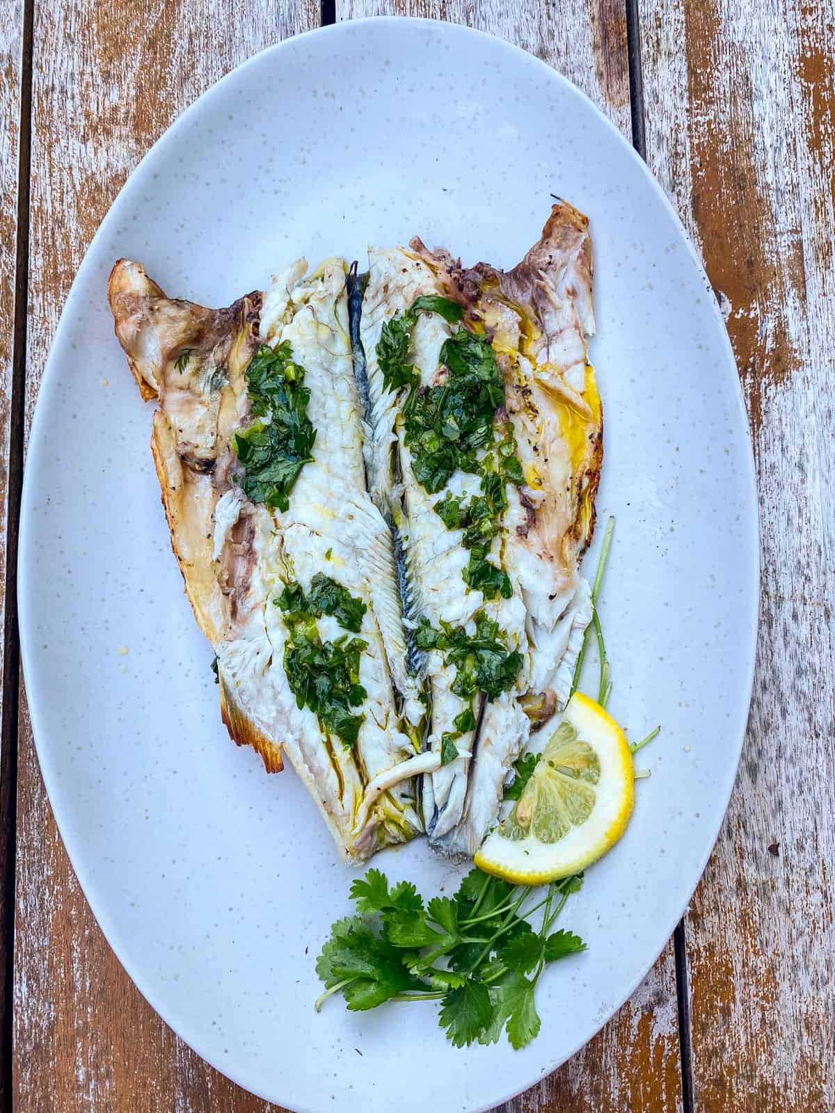 Grilled branzino with herb oil on top.