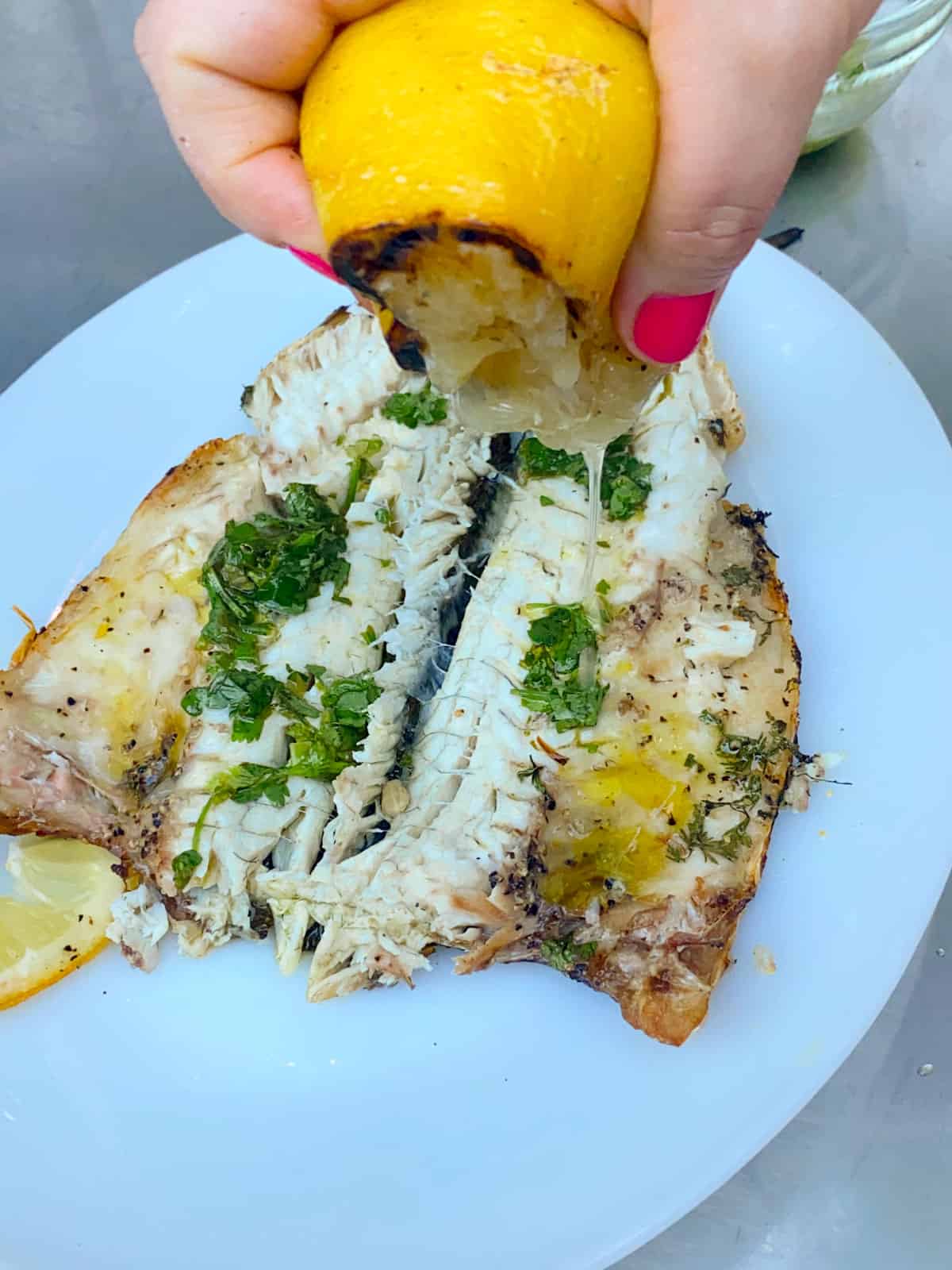 Squeeze grilled lemon onto the grilled branzino filet.
