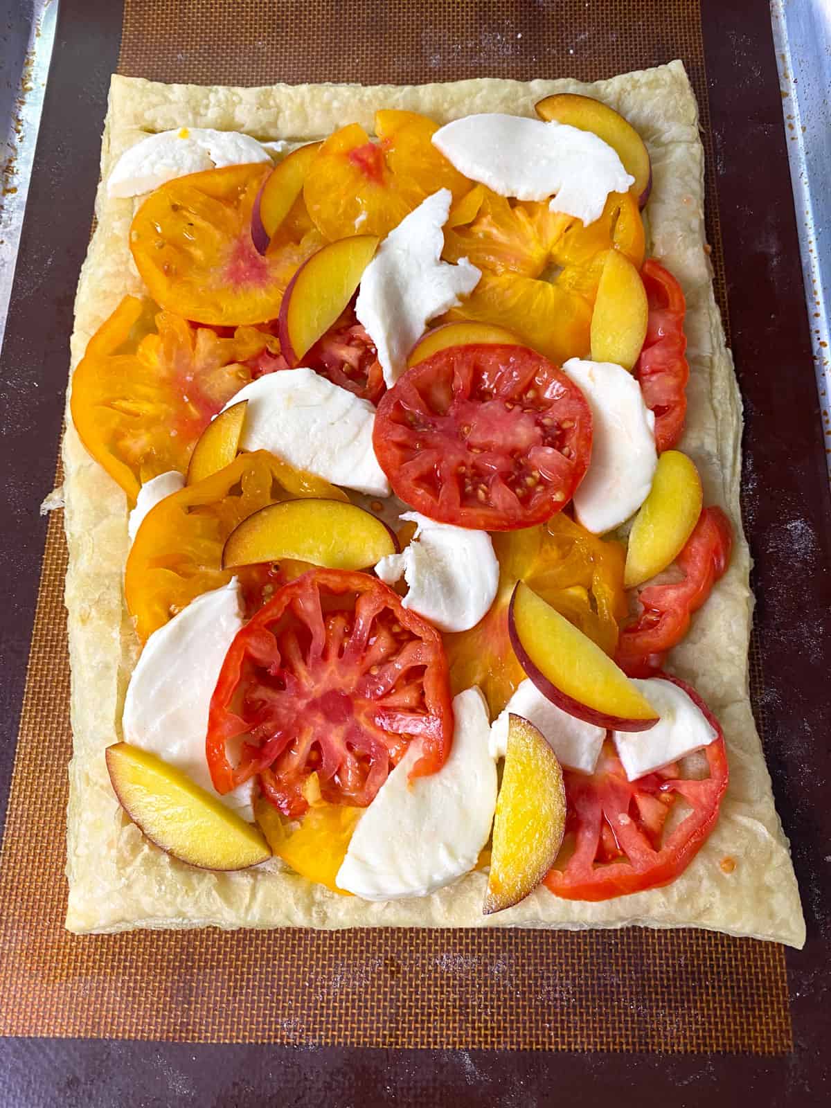 Layer the puff pastry with mozzarella, slices of heirloom tomato and sliced peaches.