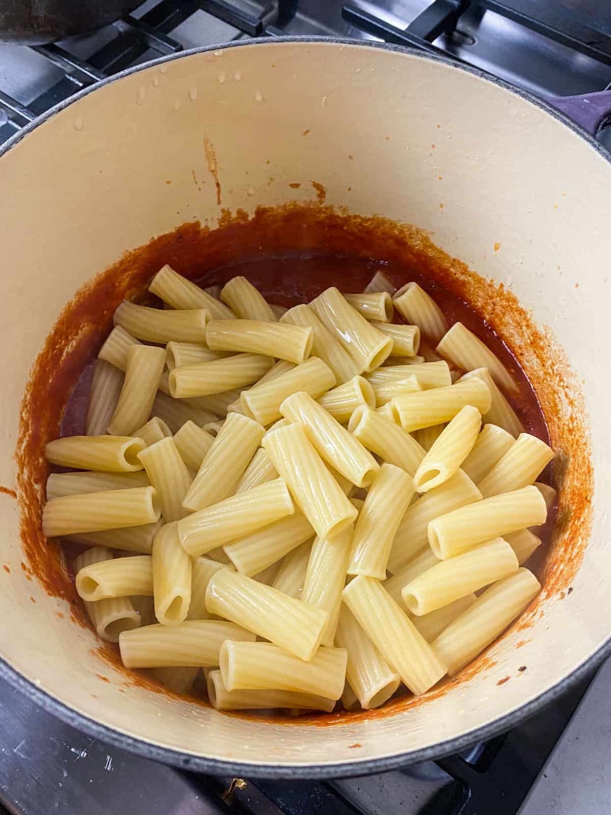 Add the cooked rigatoni pasta to the marinara sauce.