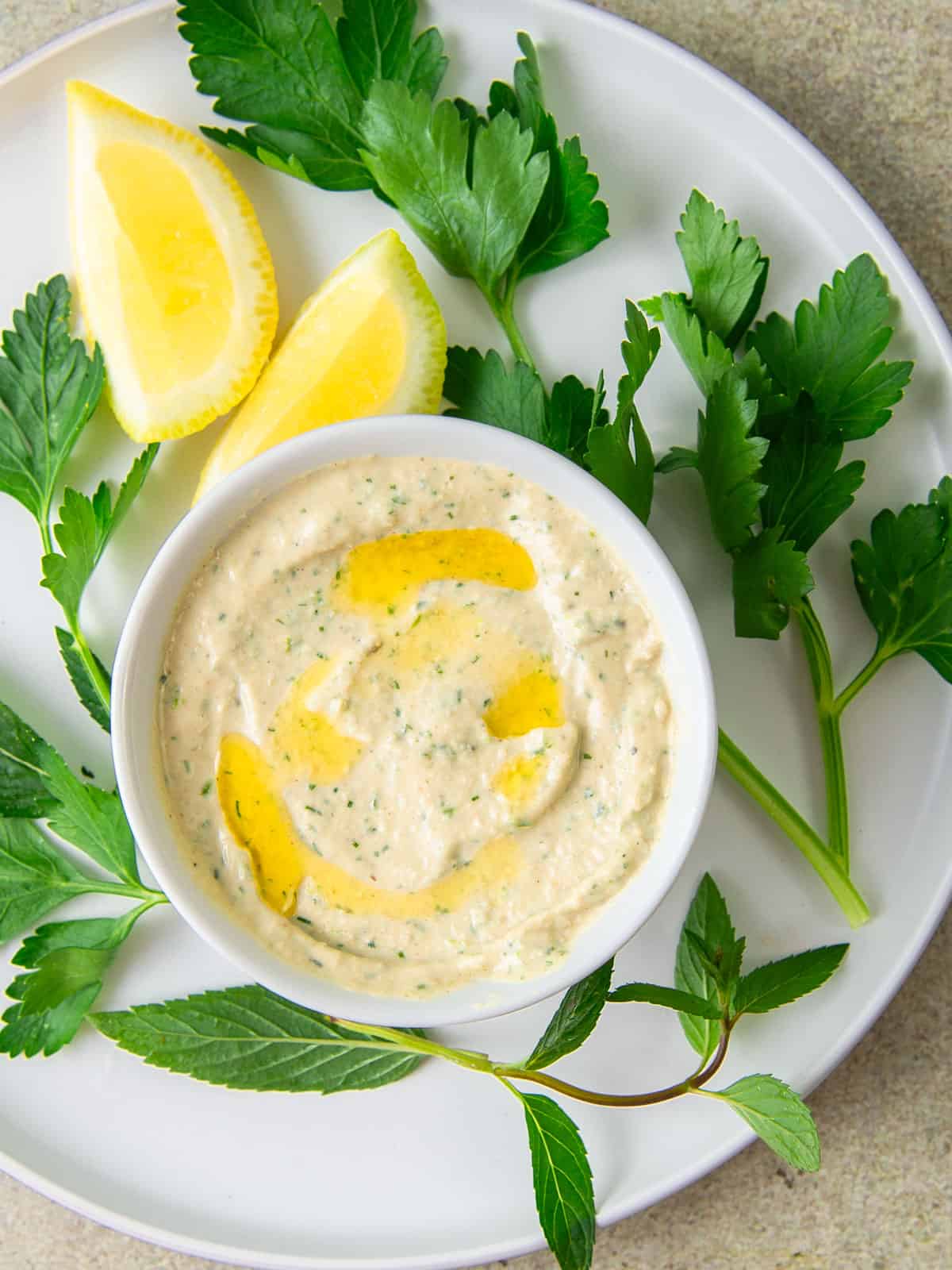 Creamy lemon tahini sauce is drizzled with olive oil.