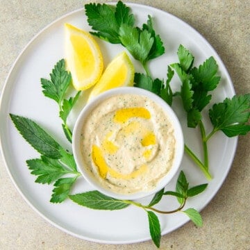 Creamy lemon tahini sauce with fresh mint and parsley.