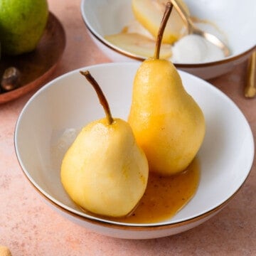 Poached pears served whole and drizzled with reduced sugar wine sauce.