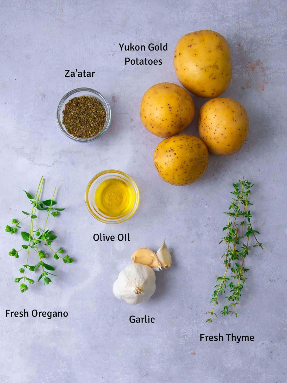 Ingredients for zaatar fries including fresh thyme and oregano and garlic.