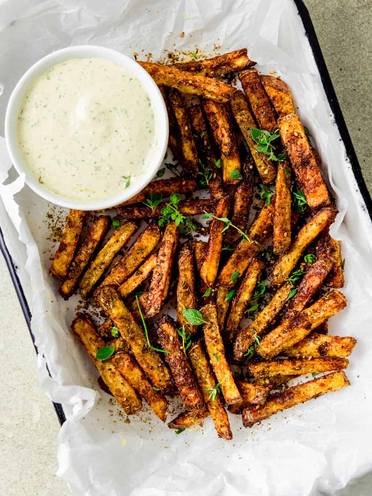 Baked zaatar fries served with creamy tahini sauce on the side.