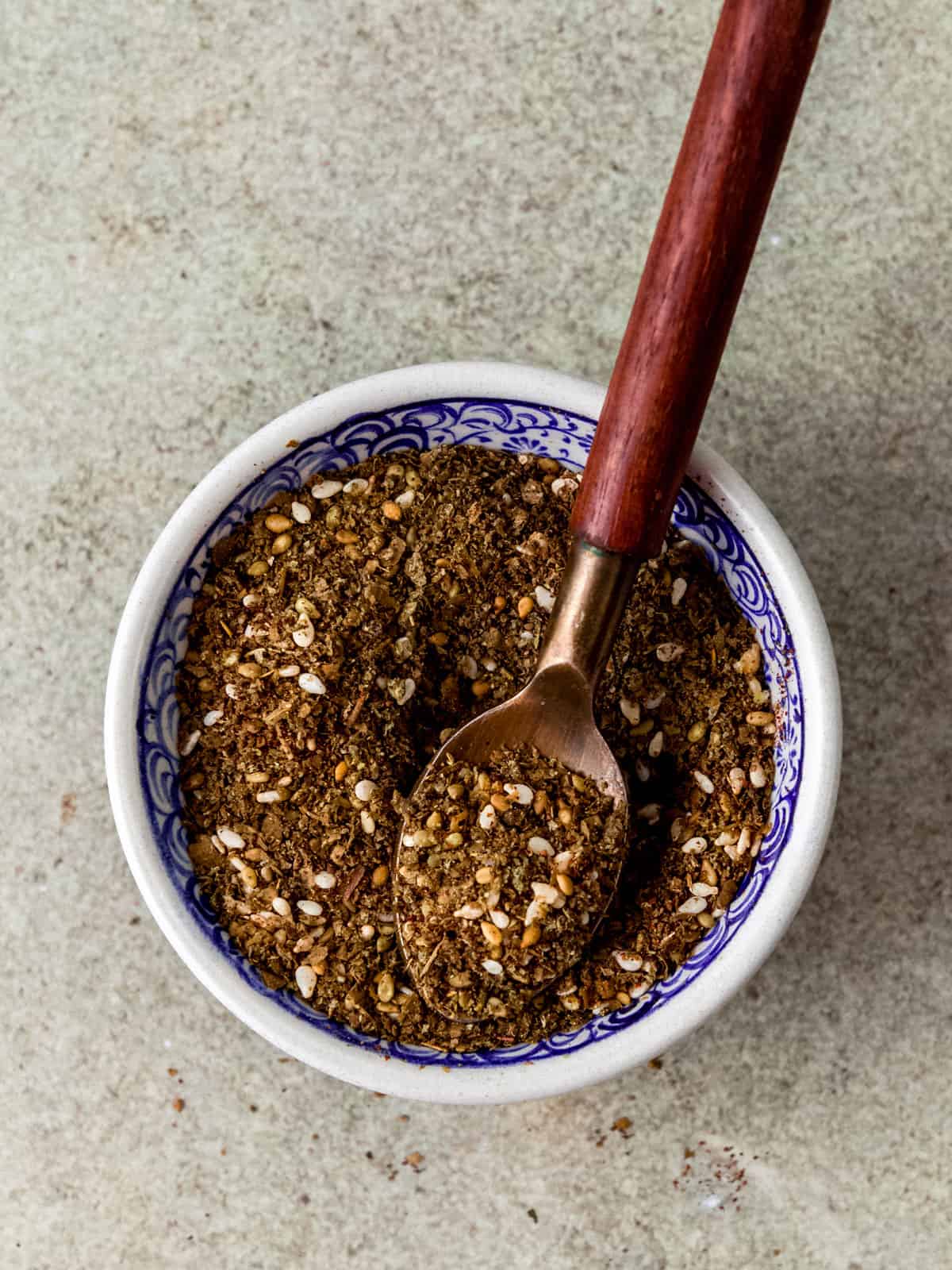 A small bowl filled with za'atar spice mix, which is a spice blend including sesame seeds, sumac and dried thyme.