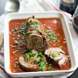 Italian beef braciole recipe served with a rich tomato sauce and garnished with fresh parsley.