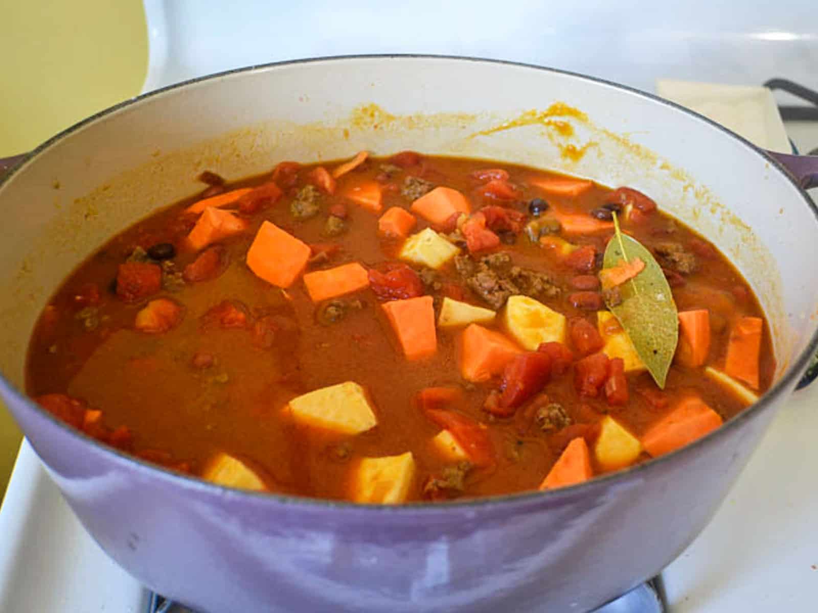 Add stock and chunks of squash into the pumpkin chili and cook until the squash is fork tender and liquid has reduced slightly.