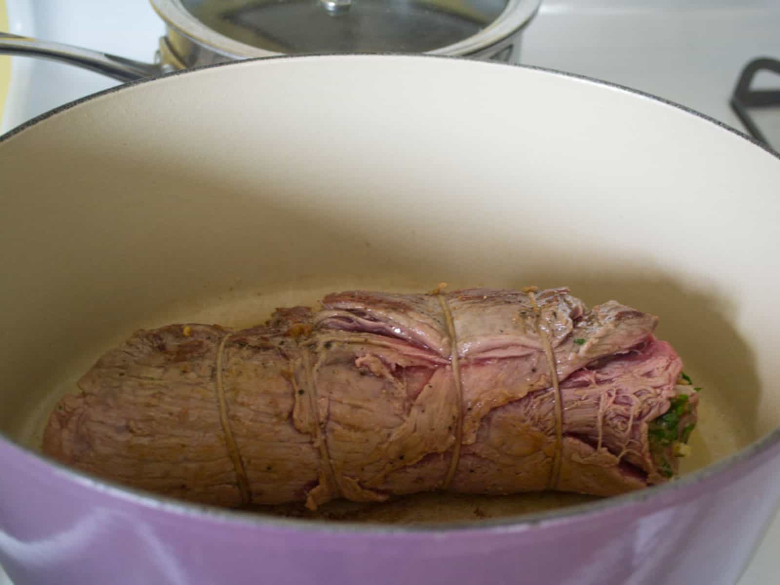 Sear the rolled beef braciole in the Dutch oven until seared on all sides.