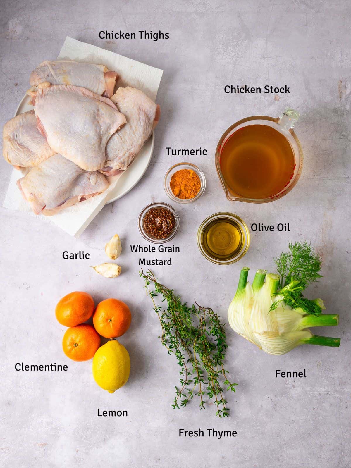 Ingredients for roasted citrus chicken with fennel, including turmeric, clementines, lemon and fresh thyme.