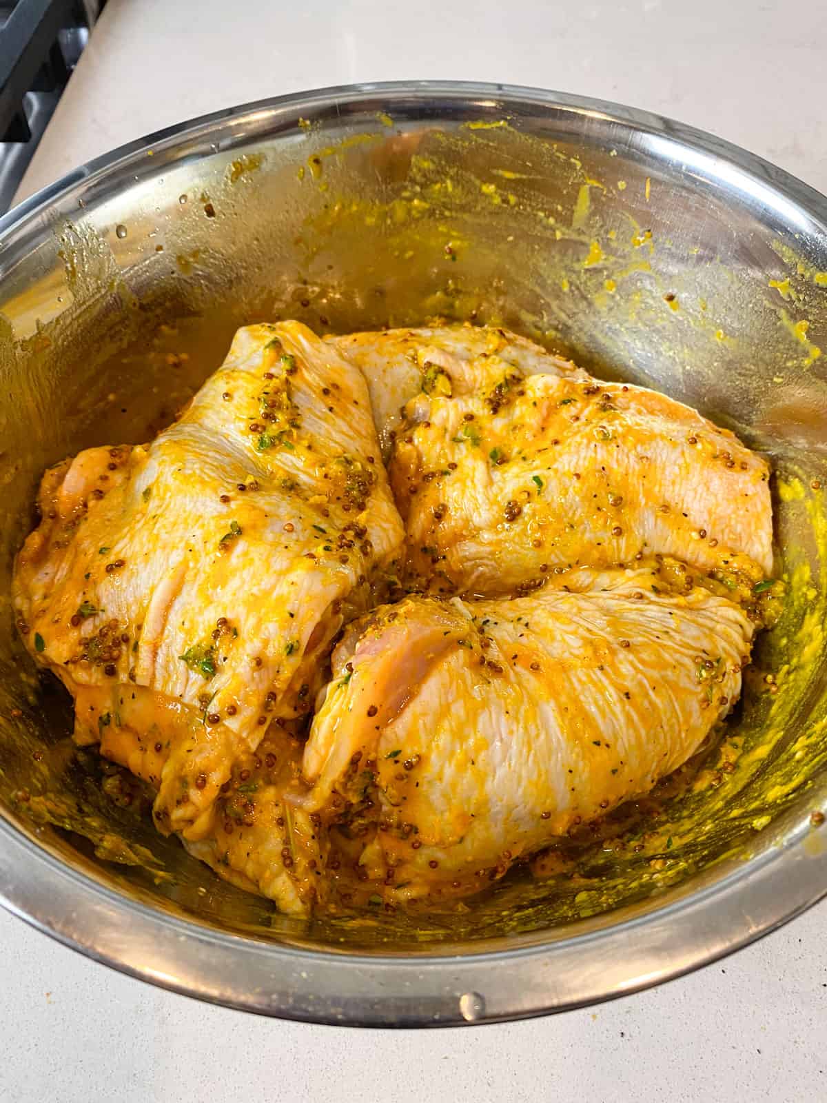Add bone in and skin on chicken thighs to the turmeric citrus marinade and toss so the marinade is evenly coated all over the chicken.