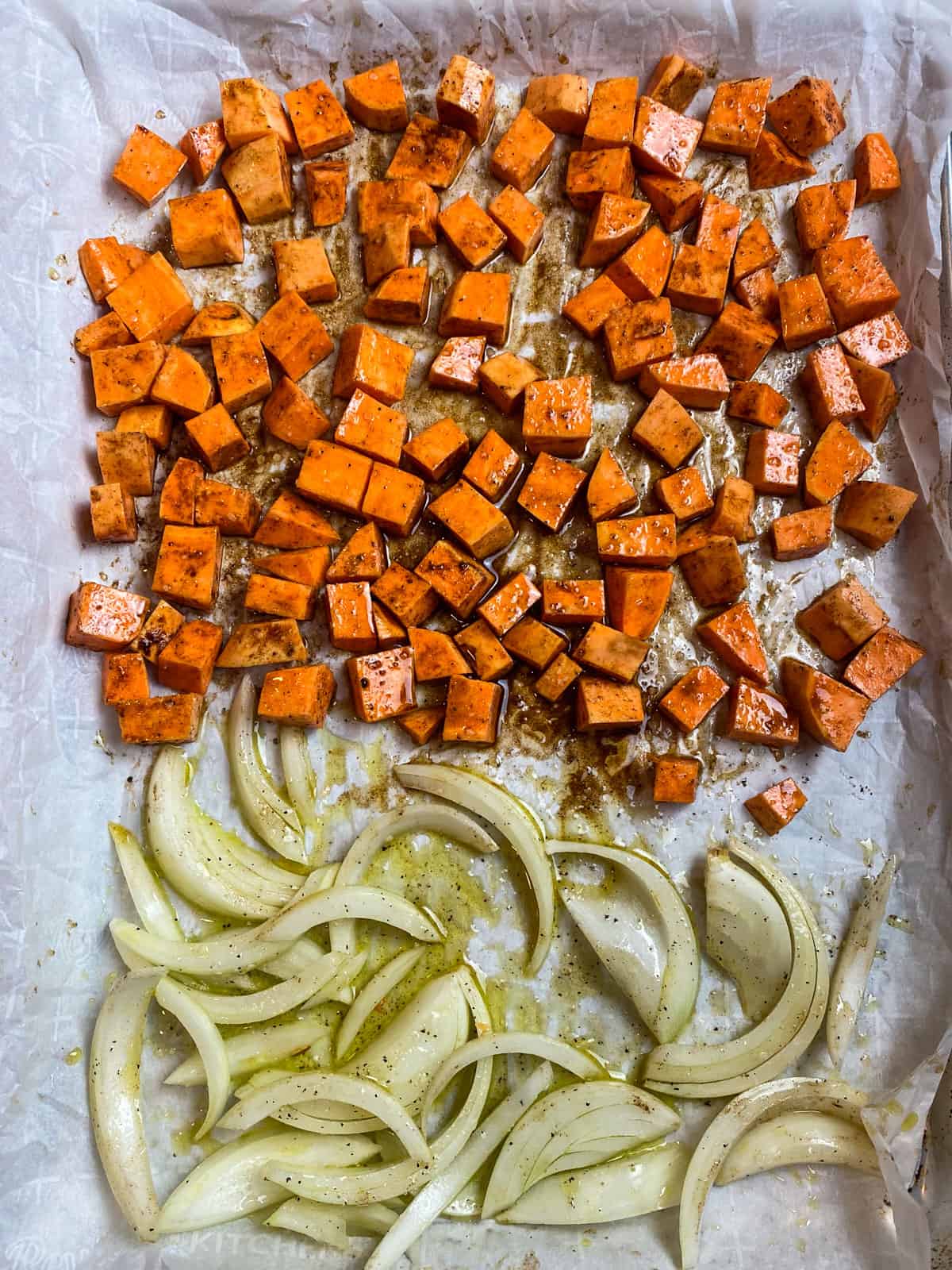 Cubed sweet potato and onion slices are seasoned with cinnamon and maple syrup before being roasted.