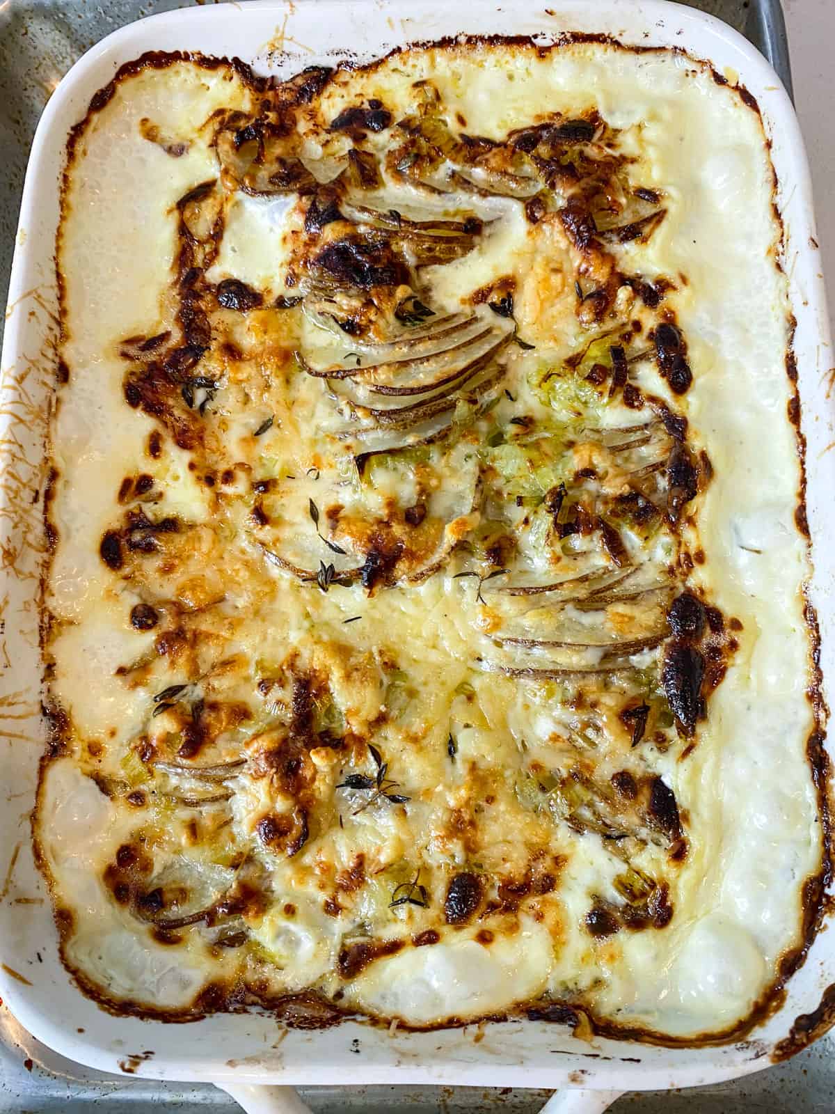 Bake the potato leek gratin until tender and bubbly. Place the gratin under the broiler to brown the top.