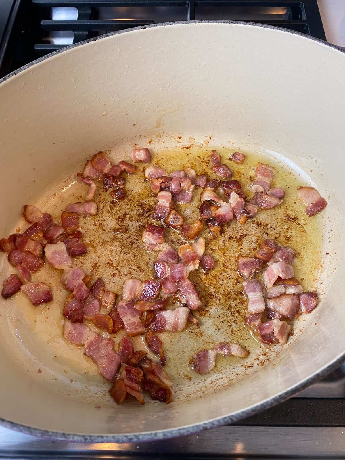 Cook chopped bacon until fat renders and the bacon is crispy, then remove and set aside.