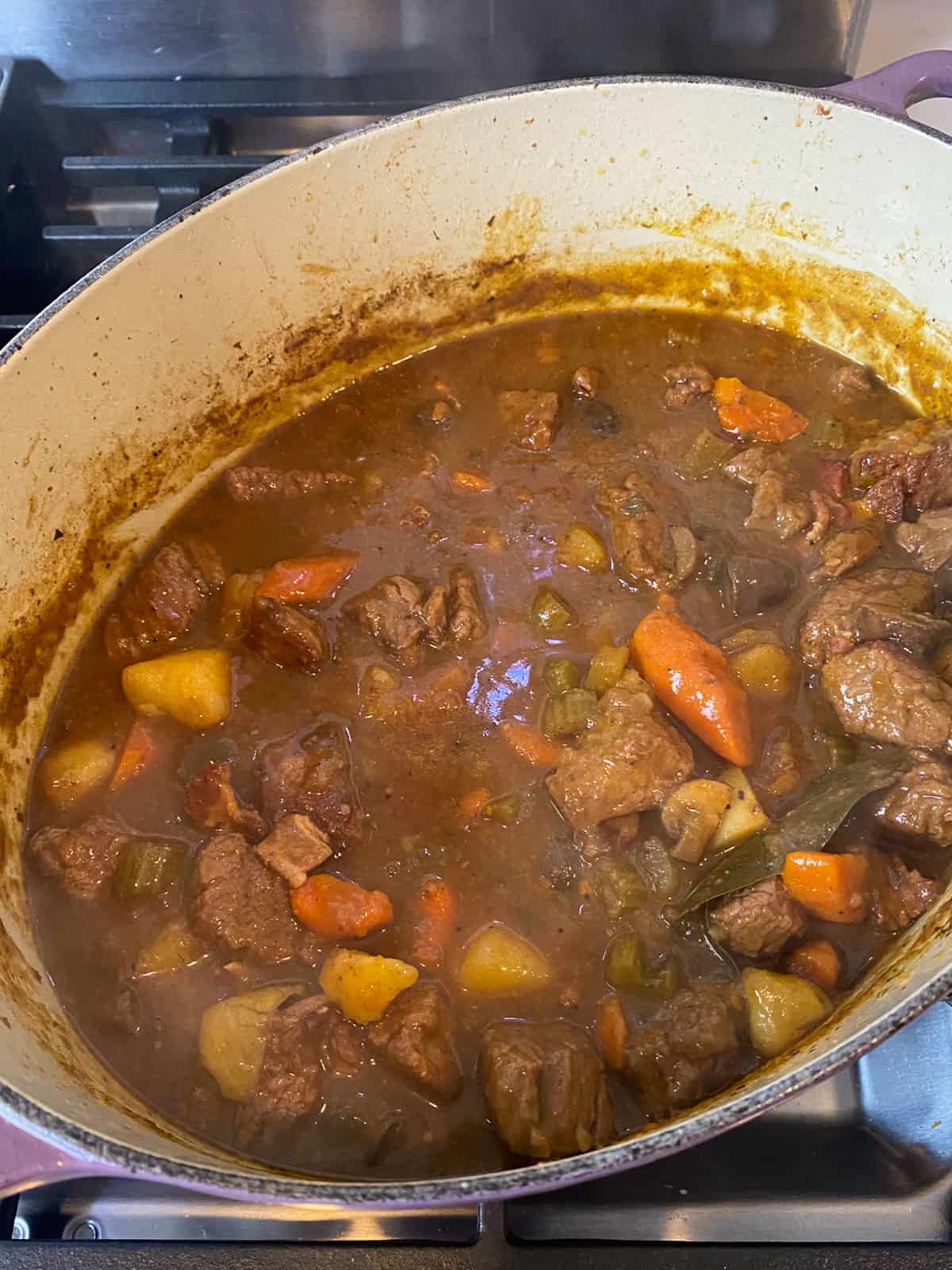 Cook the beef stew for several hours until the vegetables are tender and broth has thickened.