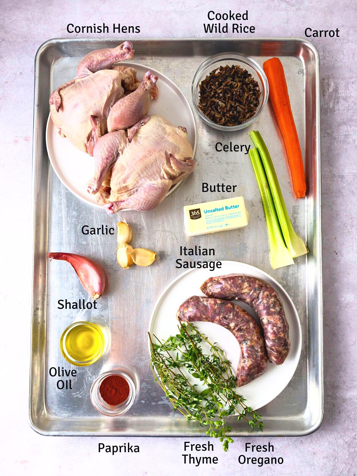 Ingredients for rice stuffed Cornish hens, including Italian sausage, herbs and compound butter.