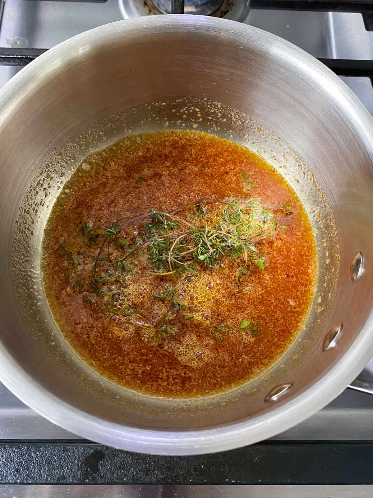 Melt the butter with fresh thyme sprogs and smoked paprika until the butter darkens into a deep rust color.