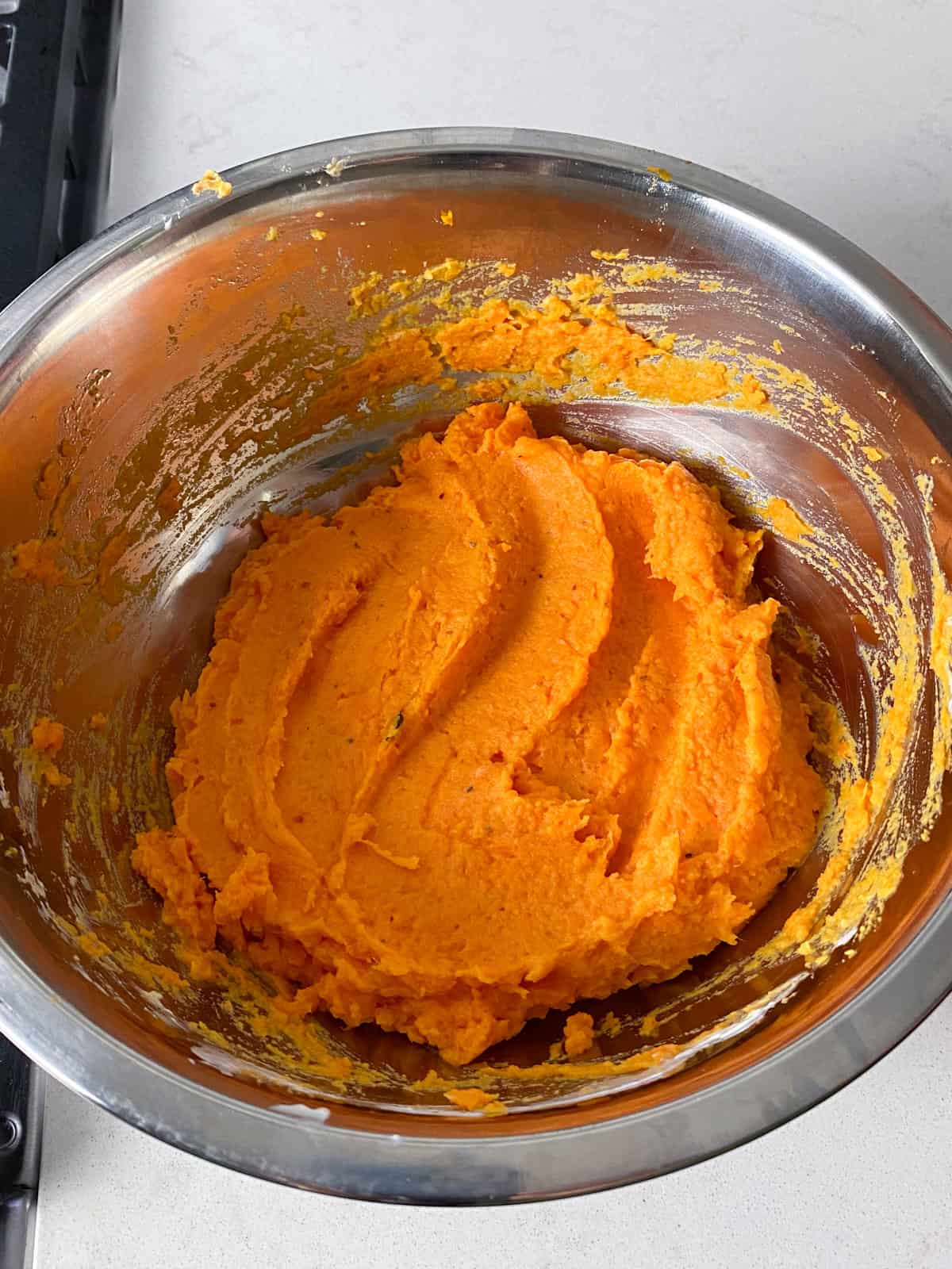 Give the mashed sweet potatoes a good mix until creamy.