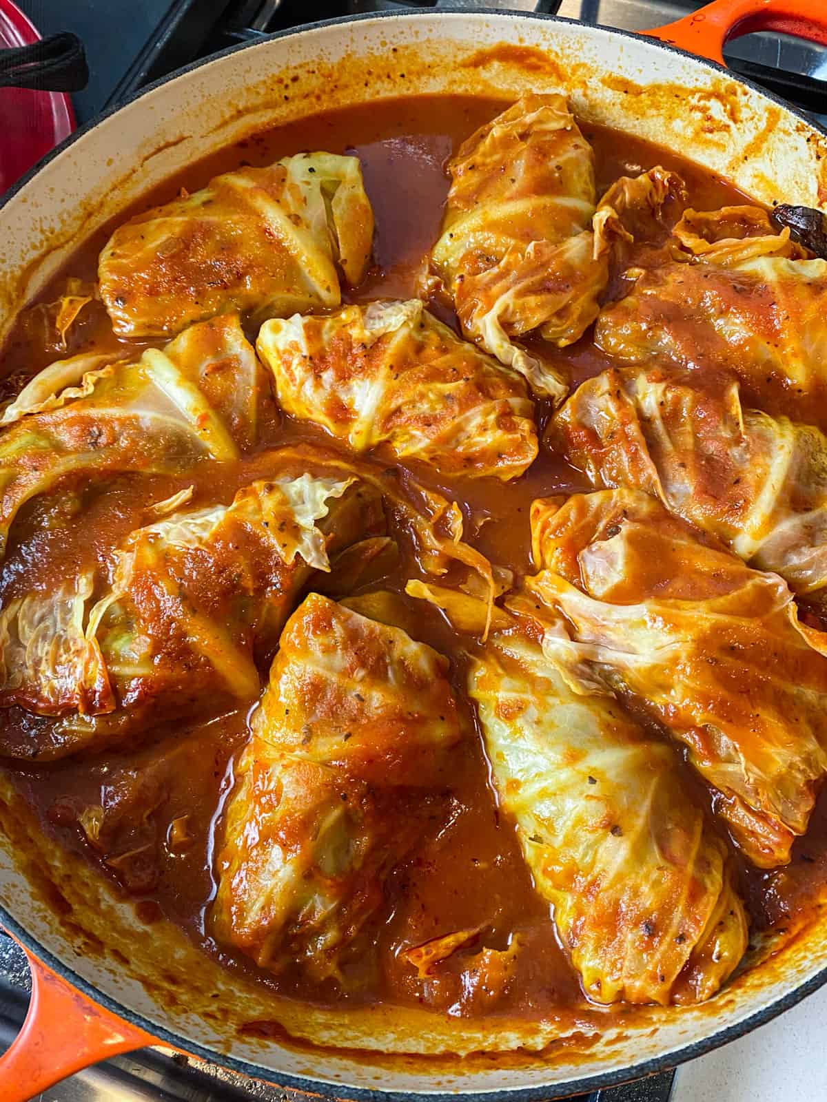 Cooked stuffed cabbage rolls in a sweet and sour tomato sauce.