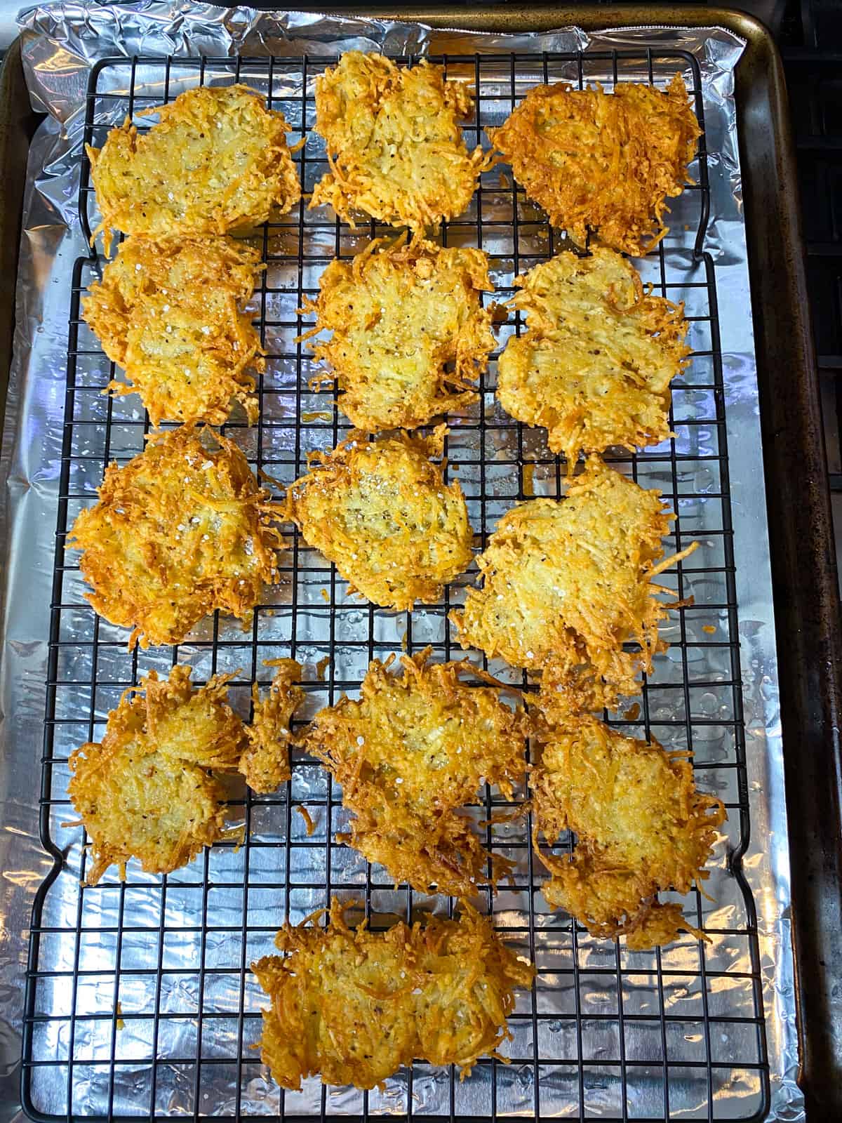 Transfer the fried celery root latkes to a wire rack to drain excess oil.