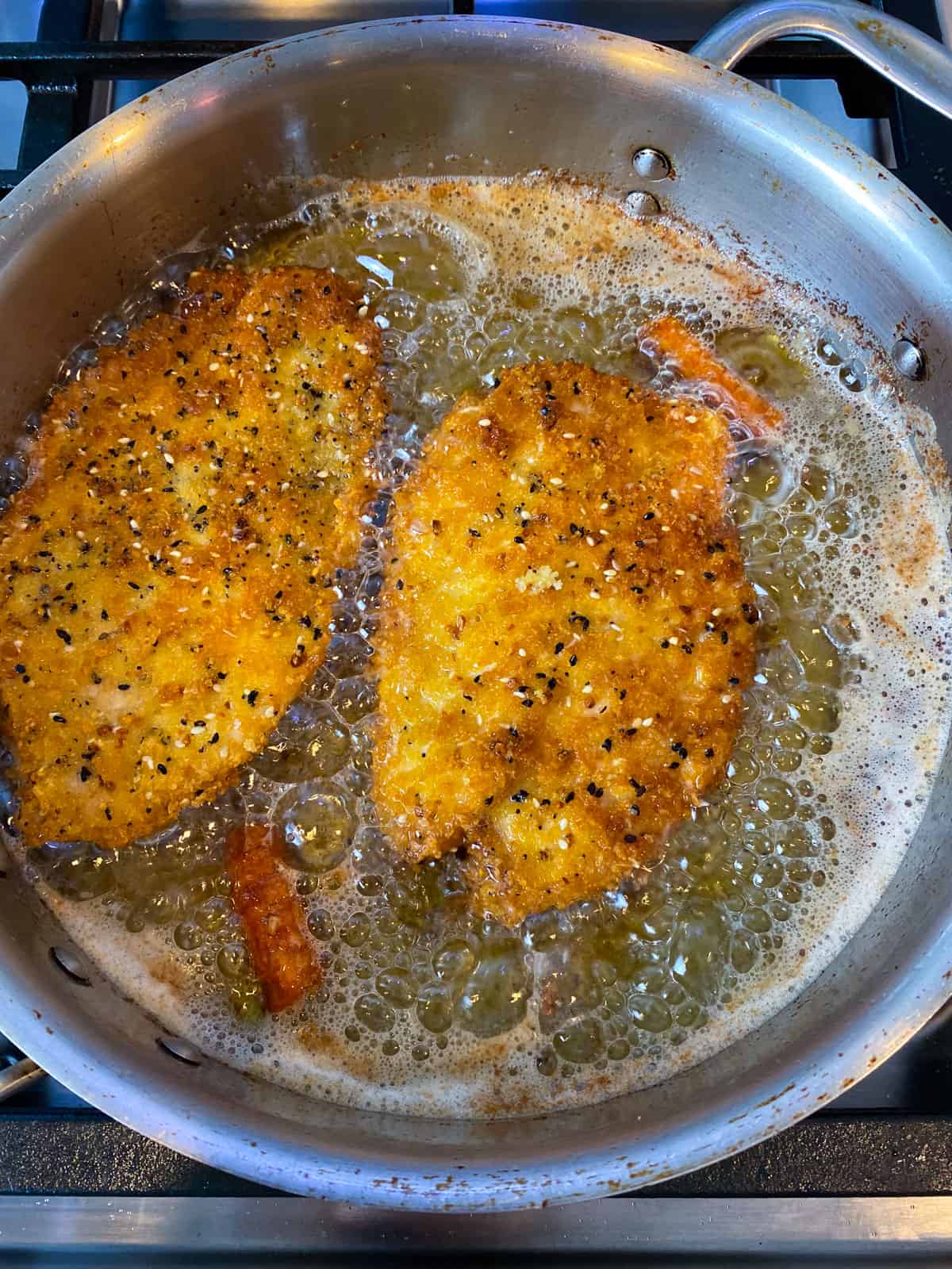 Turn the chicken cutlets over and fry on the other side until crisp and golden brown.