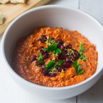 Muhammara dip topped with pomegranate seeds and lemon zest.