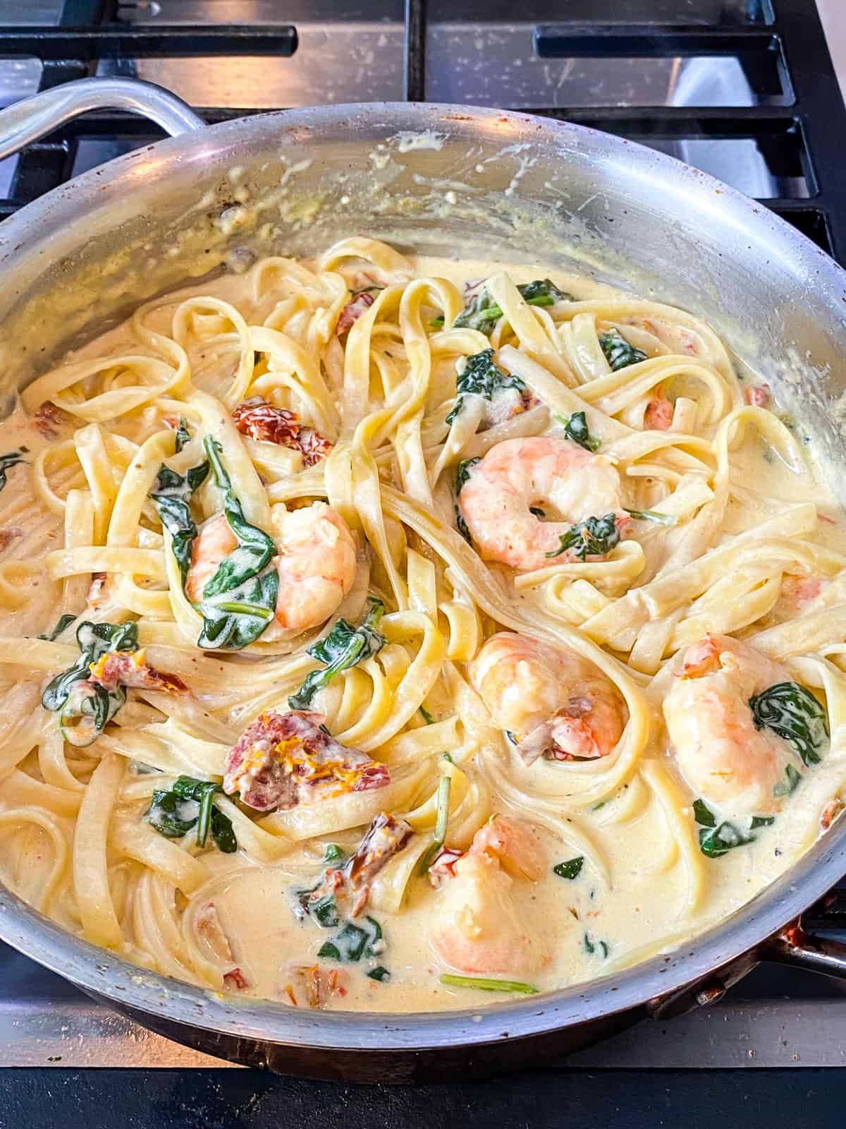 Add cooked pasta to the creamy tuscan shrimp.