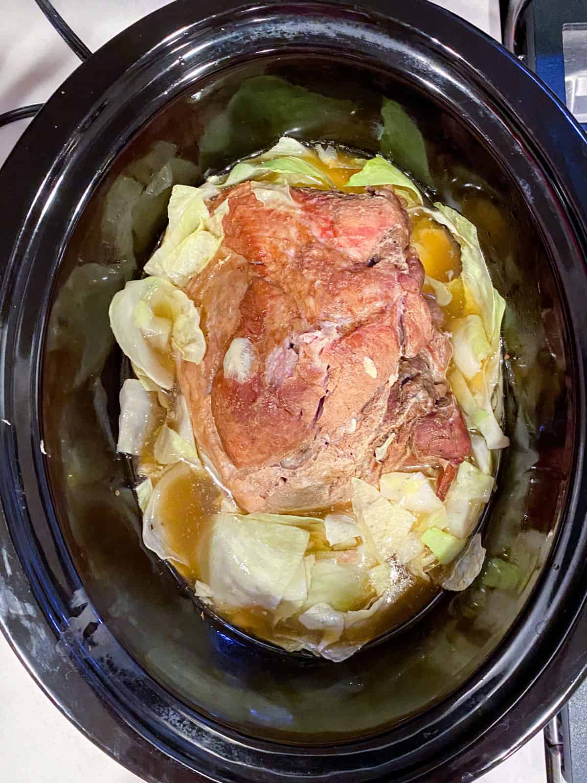 Cooked kalua pork with cabbage in the slow cooker.