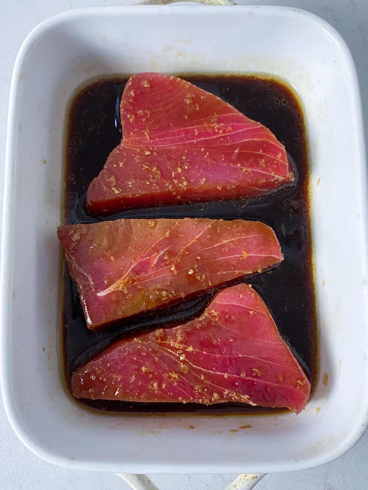 Marinate the raw tuna in a soy sauce mixture with ginger, garlic, honey and rice wine vinegar.