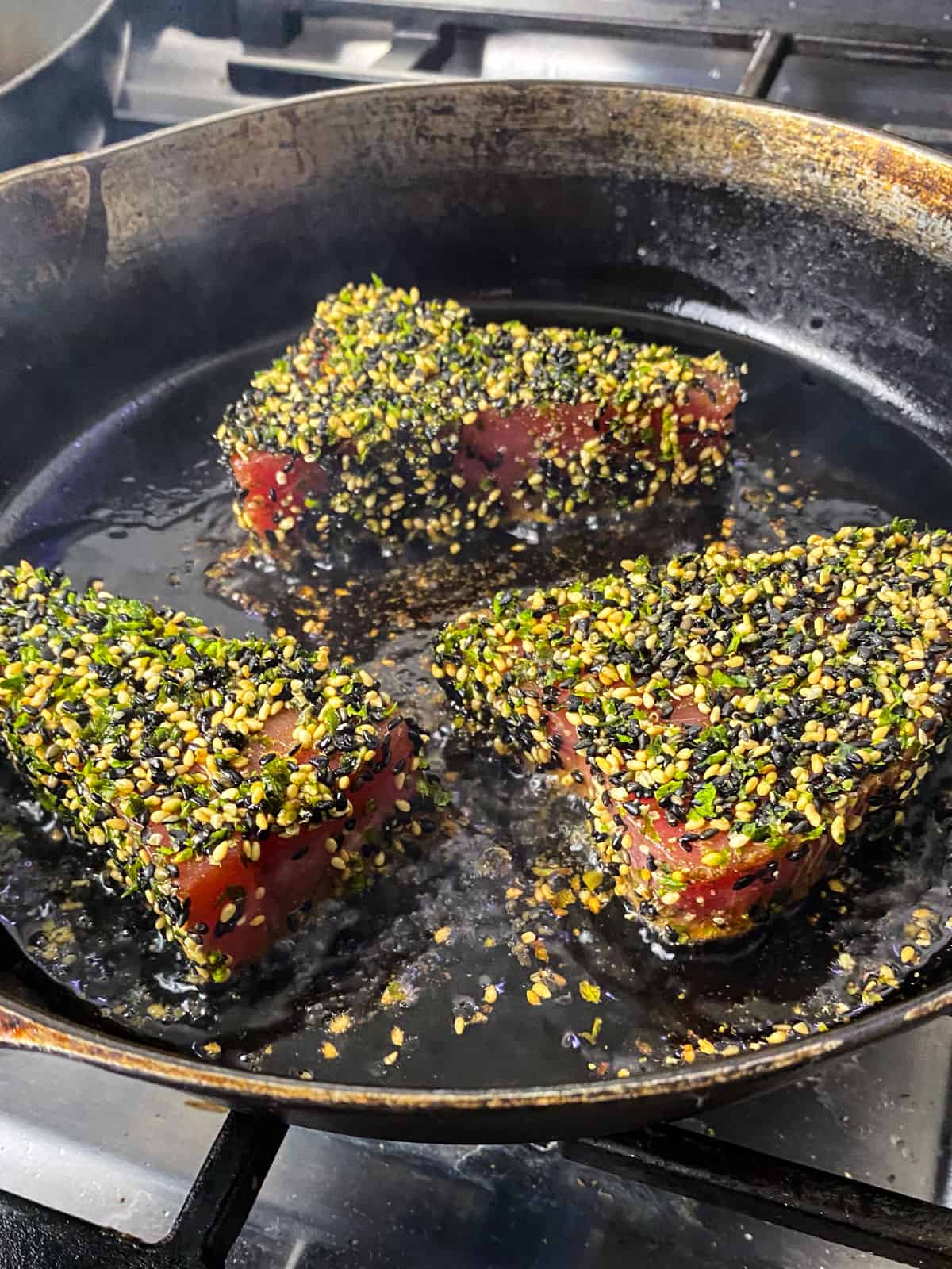 Sear the furikake crusted tuna in a hot cast iron for 90 seconds on the first side.