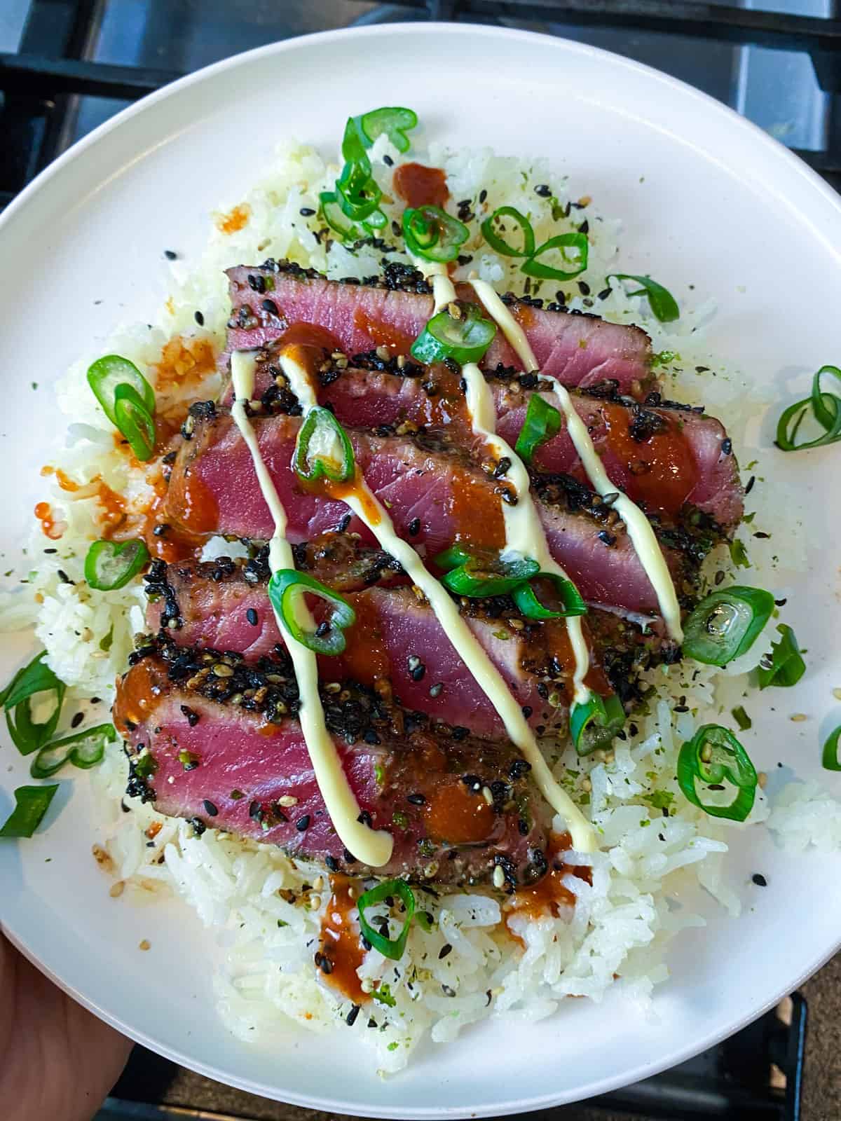 Serve the seared ahi on top of cooked white rice and drizzle with sriracha and Japanese mayo.