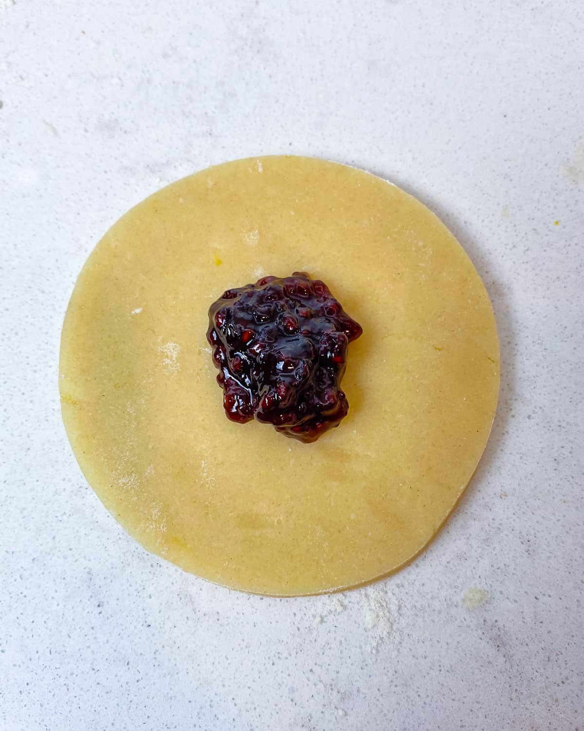 Place a teaspoon of jam in the center of the dough circle.