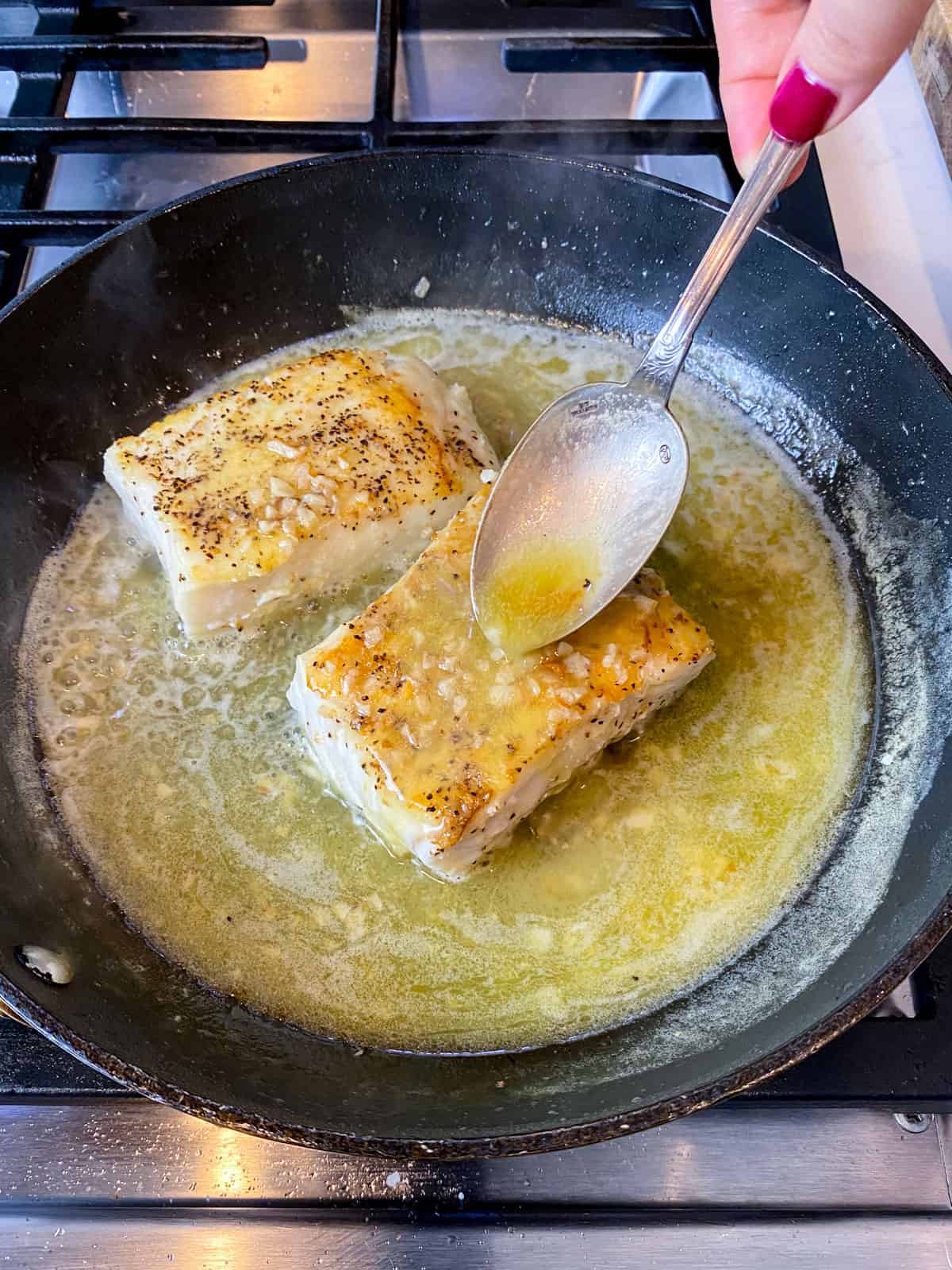 Baste the seared halibut with the lemon butter sauce.