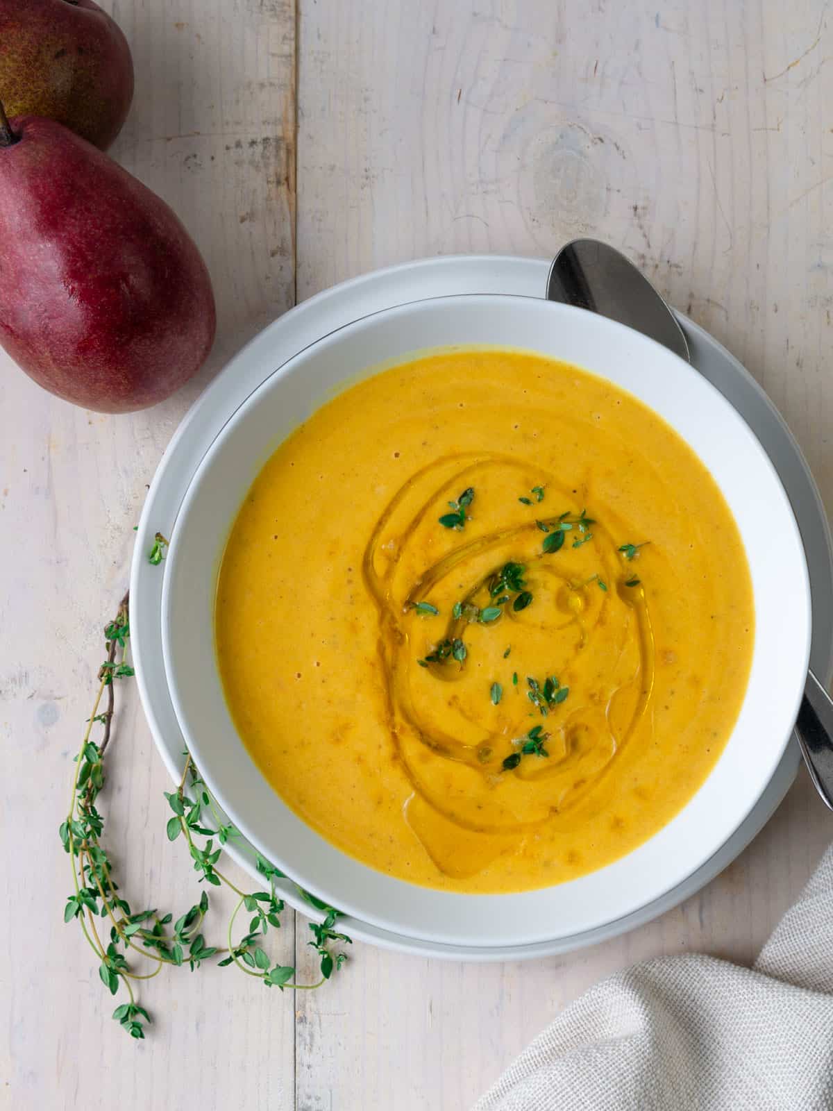 Creamy pear and butternut squash soup topped with fresh thyme.