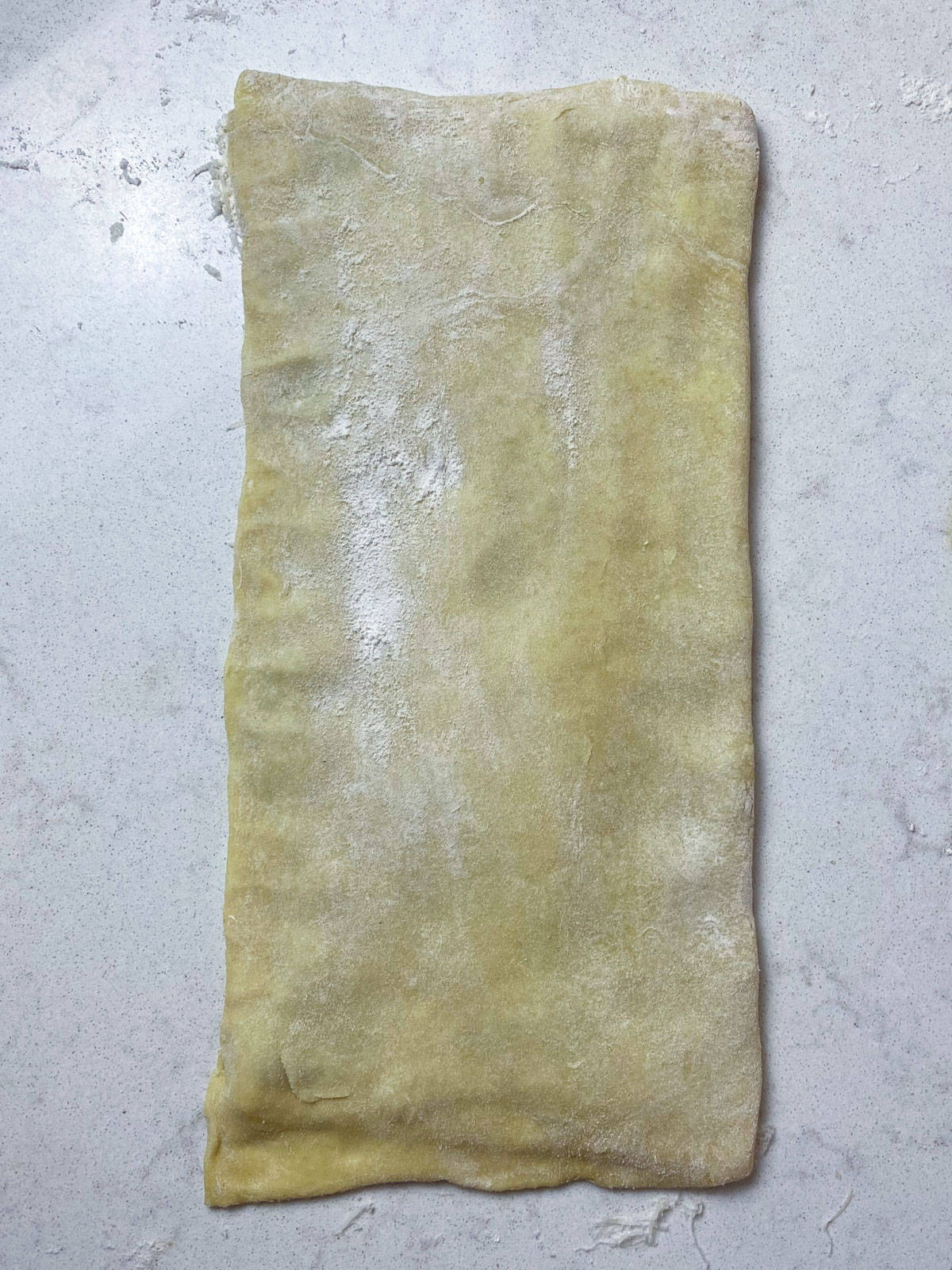 Fold the other half of the puff pastry over the olive tapenade and seal the edges.