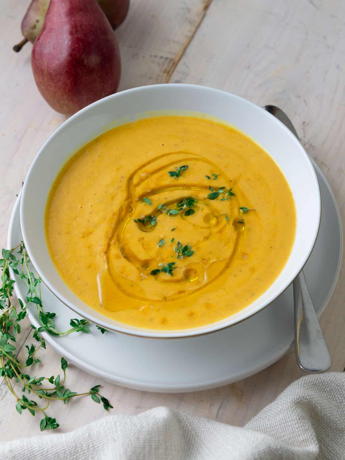 Creamy pear and roasted butternut squash soup topped with fresh thyme.