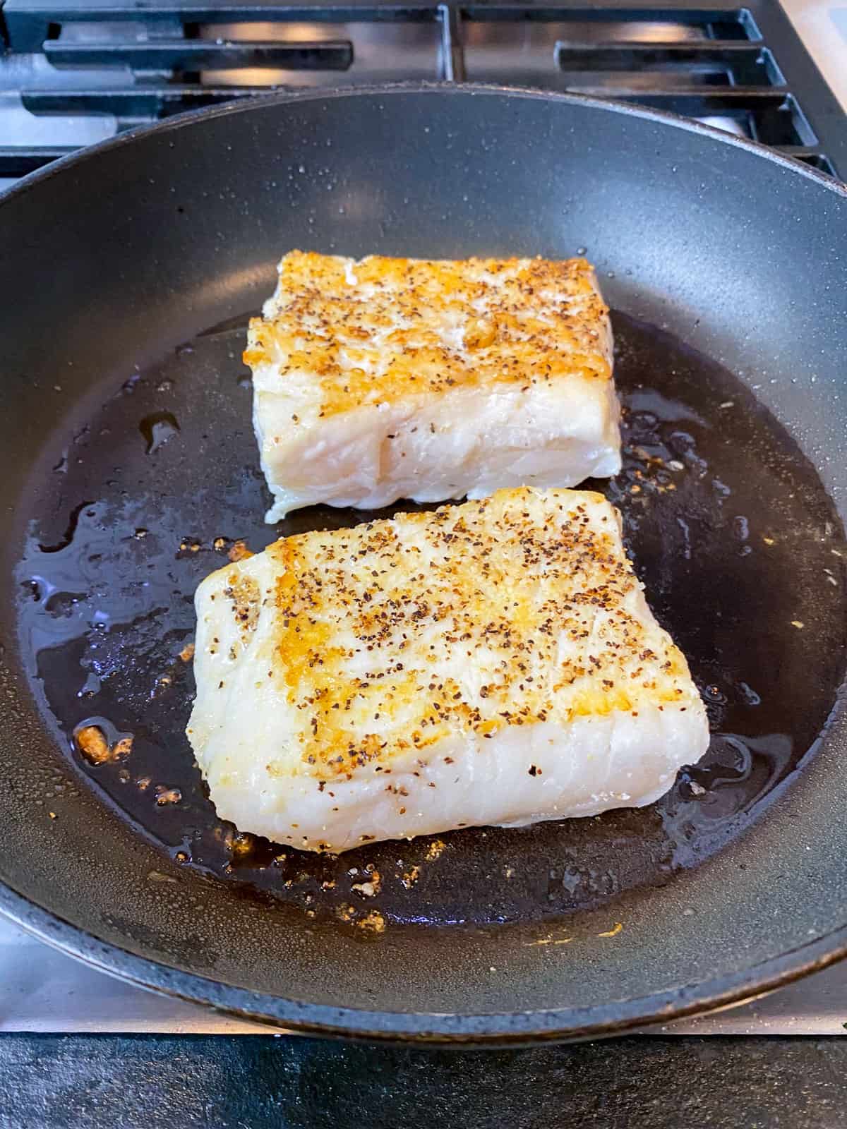 Sear the halibut filets until deeply golden on both sides.