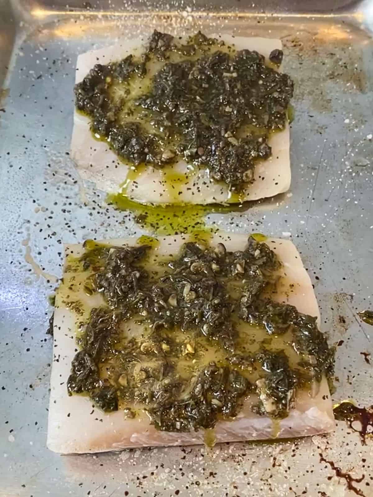 Spread a layer of pesto on top of the halibut filets.